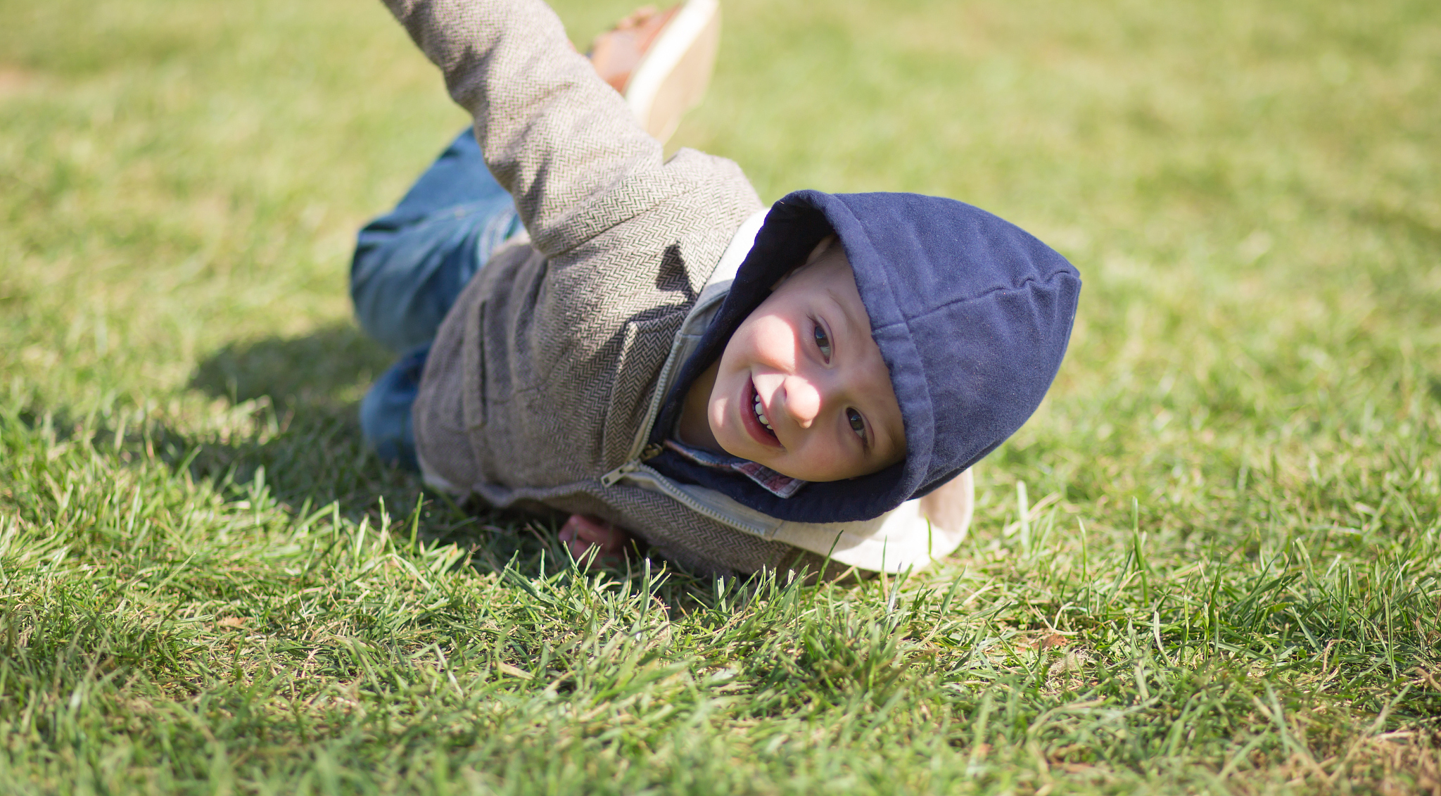 happy toddler rolling on the ground