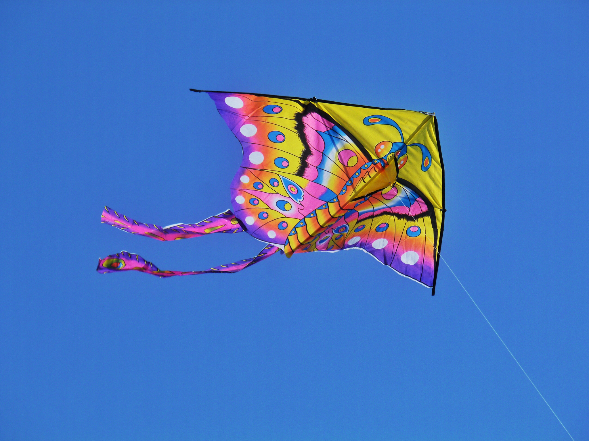 low angle view of colorful kite flying against clear sky
