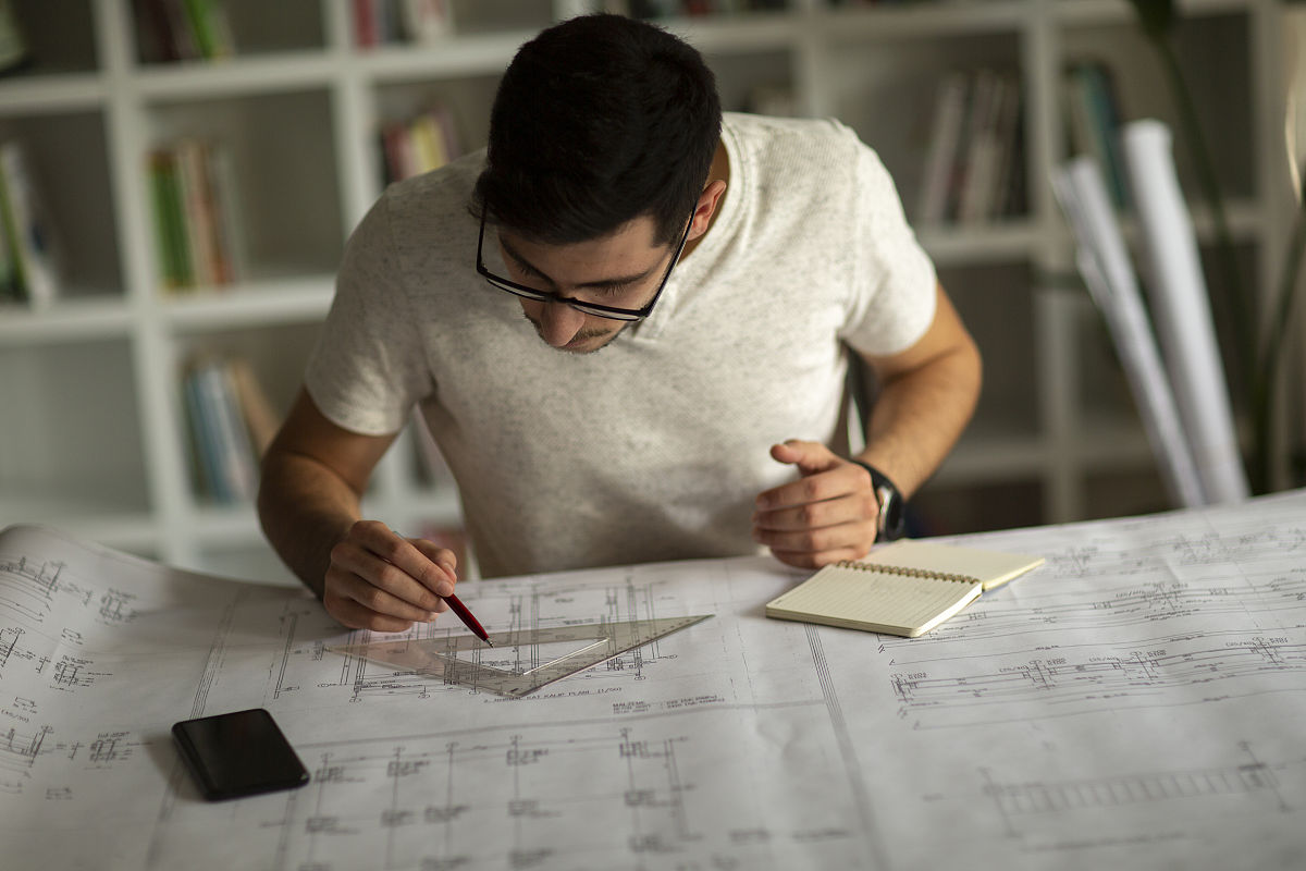 建筑师在工作室设计施工图,草图,图纸和制作建筑模型