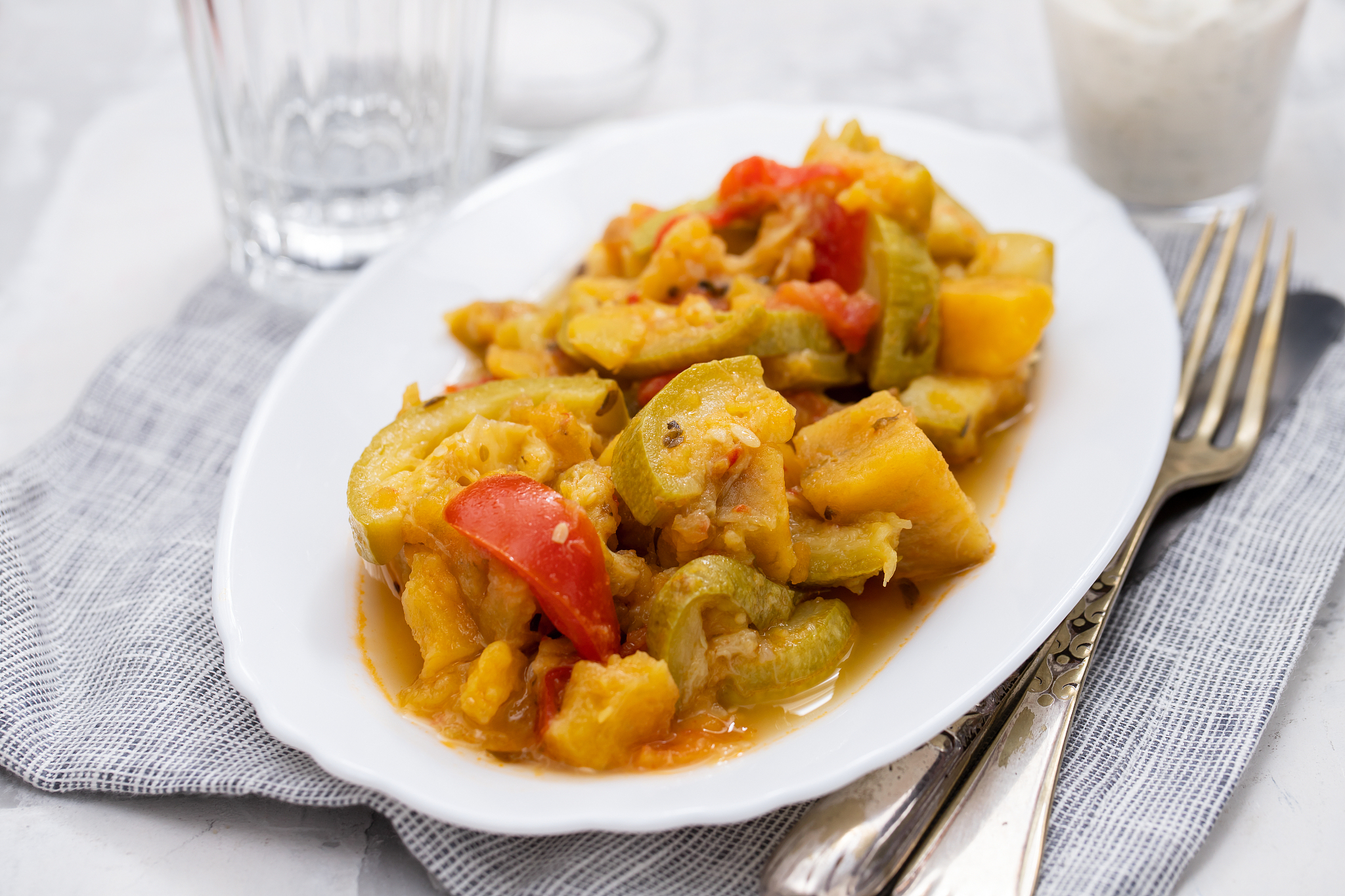vegetable stew in white dish on ceramic background