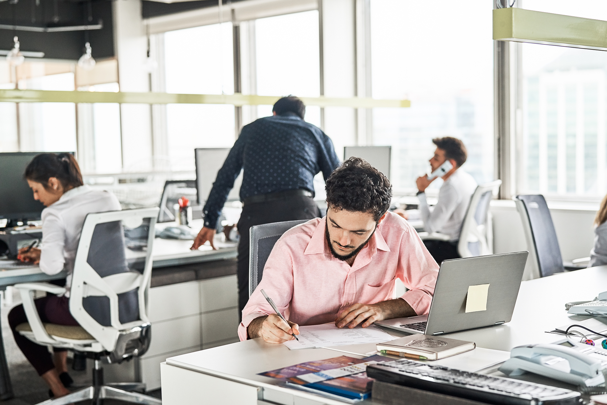 businessman writing report at desk in office