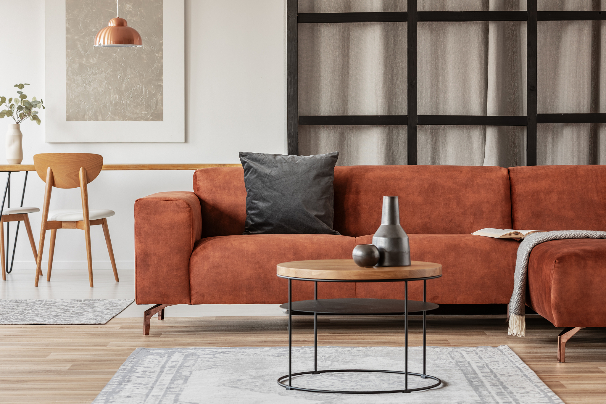 stylish corner sofa with black pillow in open space studio apart
