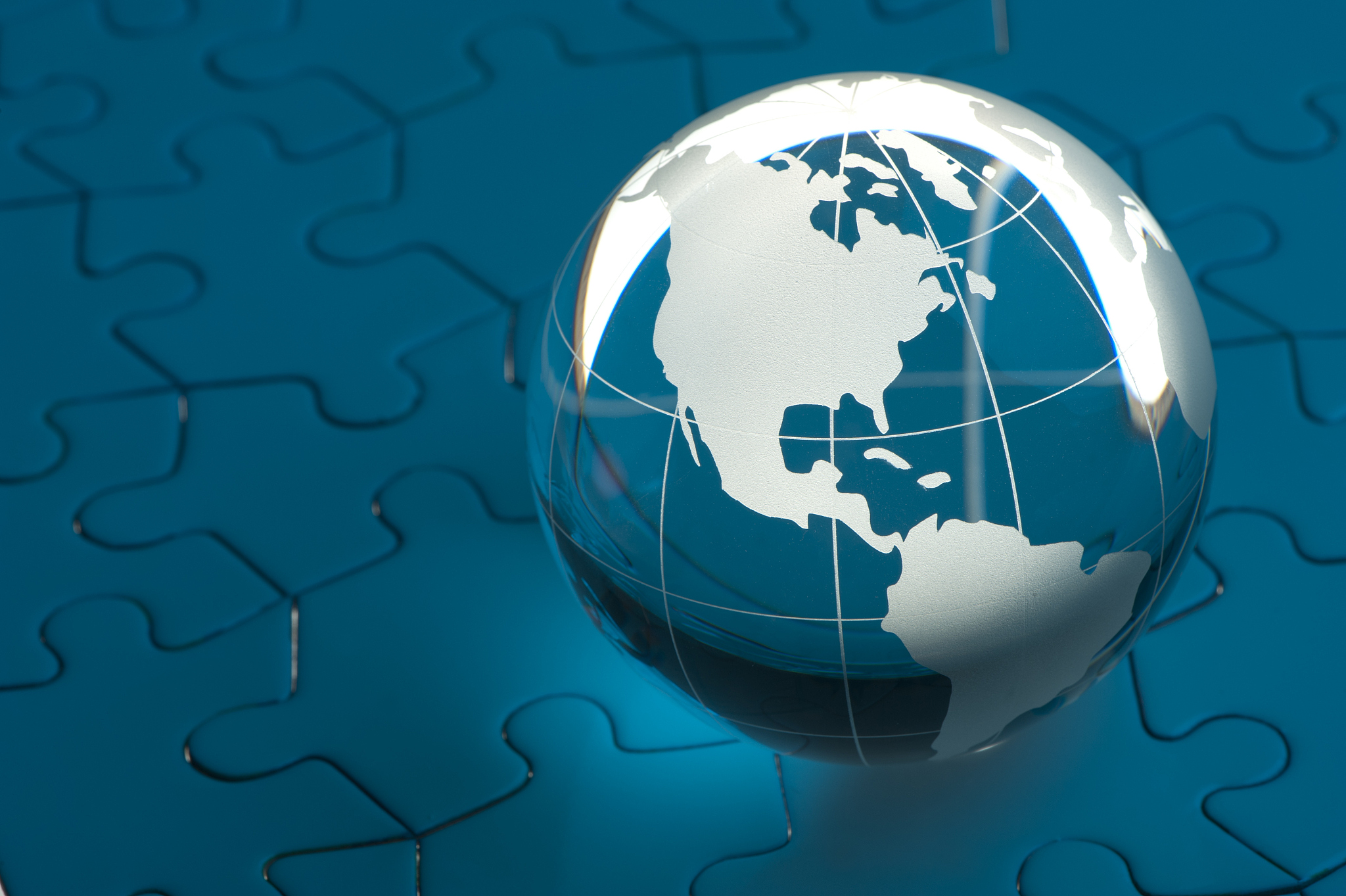 glowing white globe on a blue jigsaw puzzle