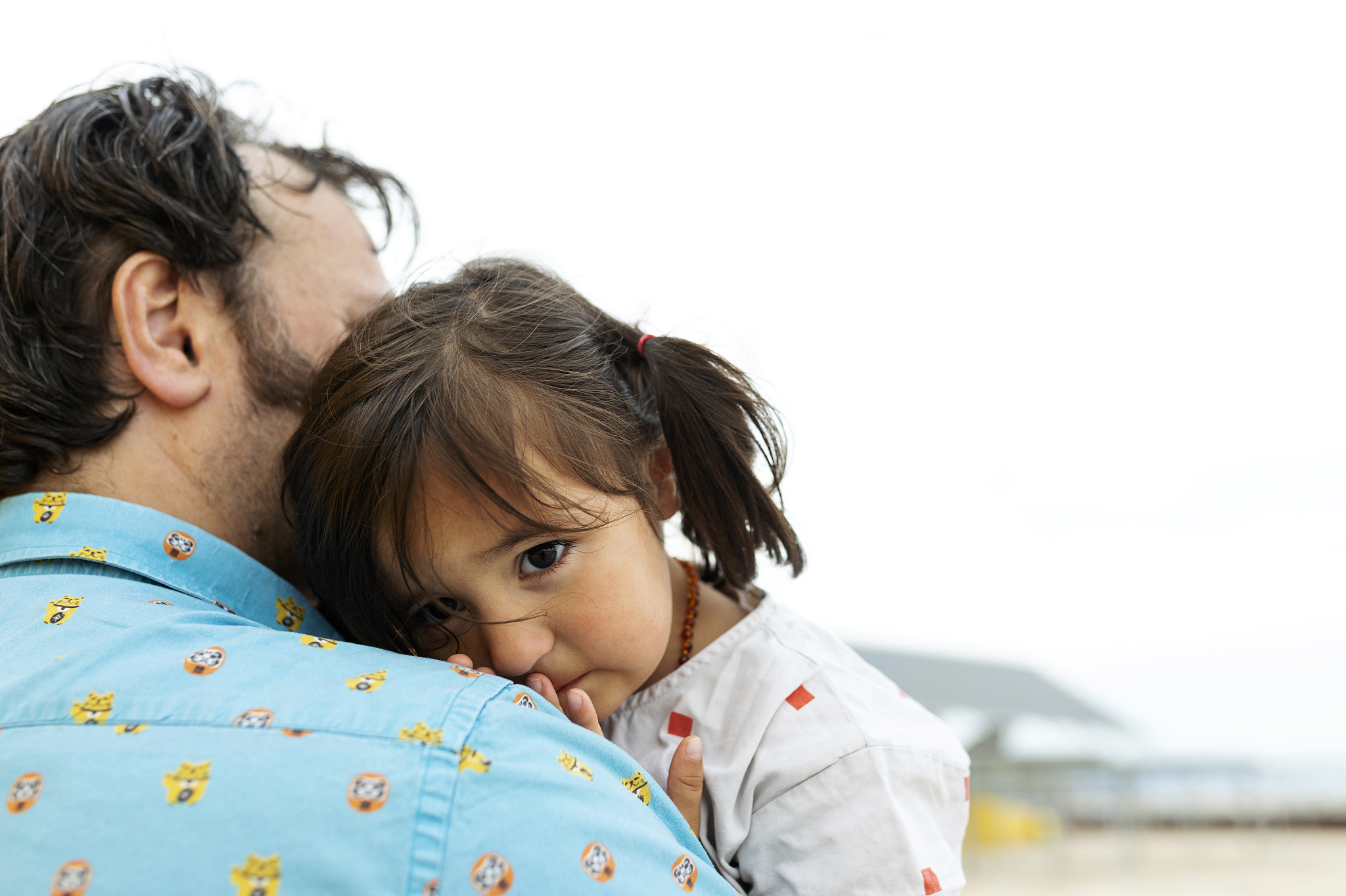 portrait of little girl leaning on father's shoulder