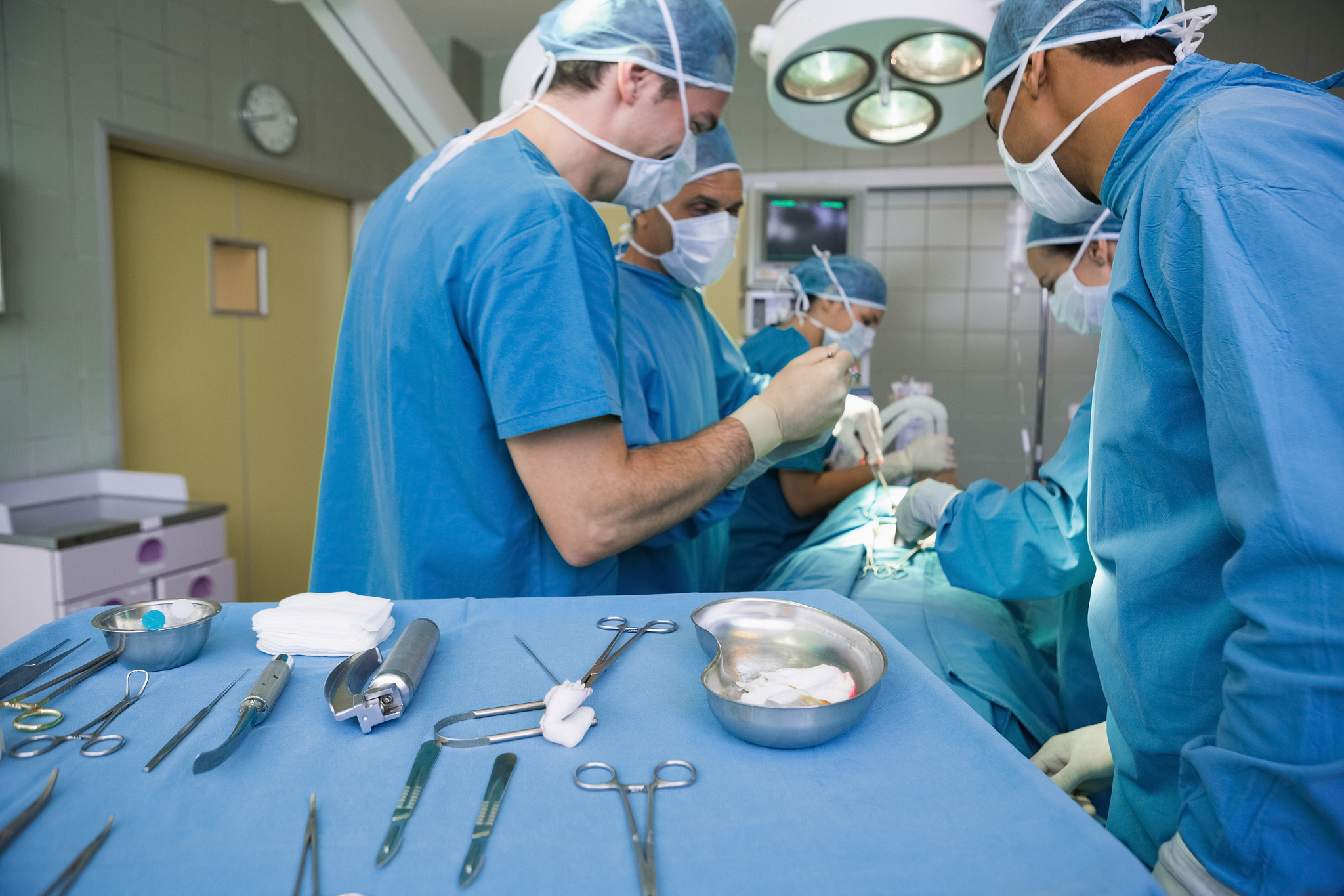 surgeon working beside a surgical trolley