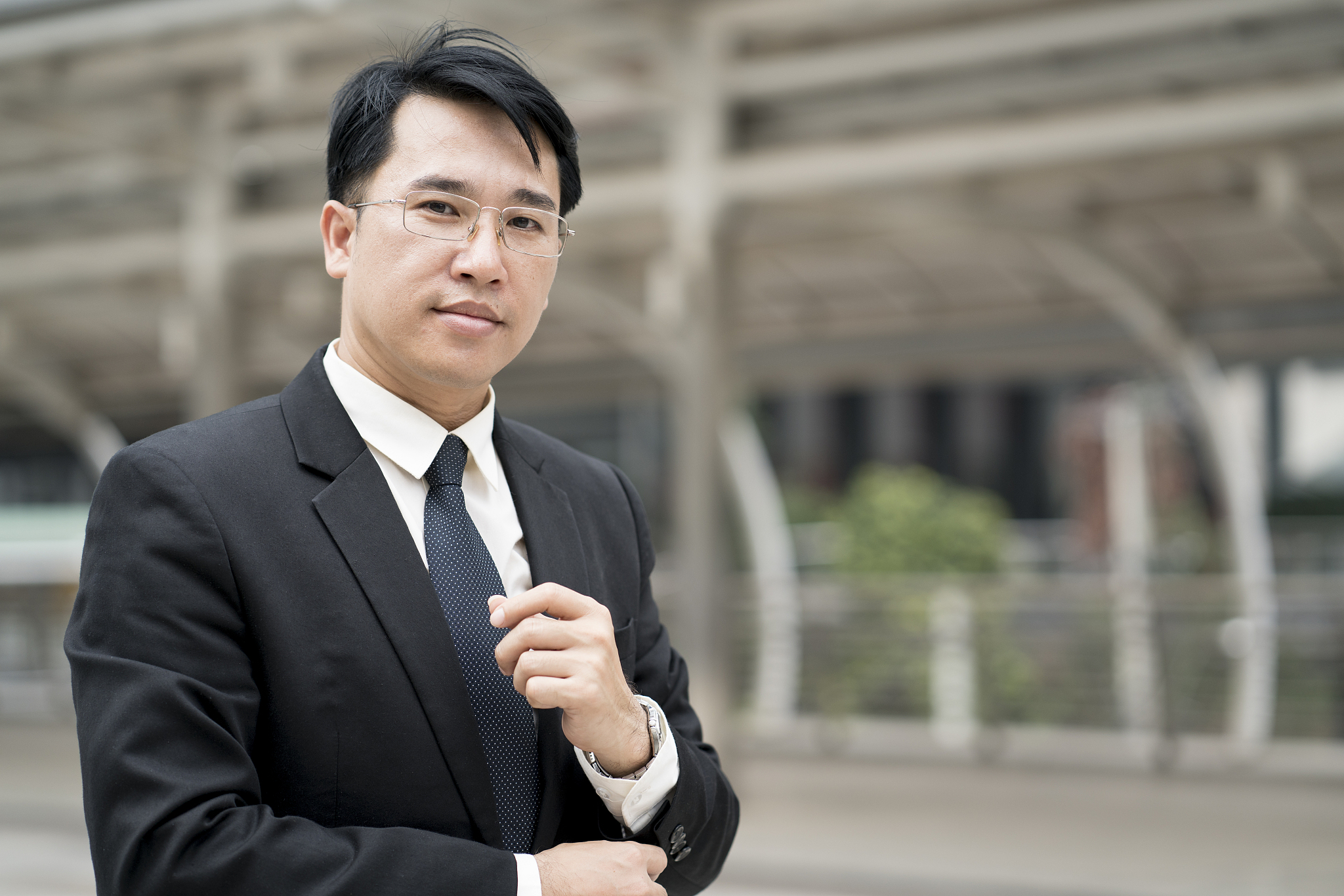 young confident asian businessman in suit standing city outdoor.