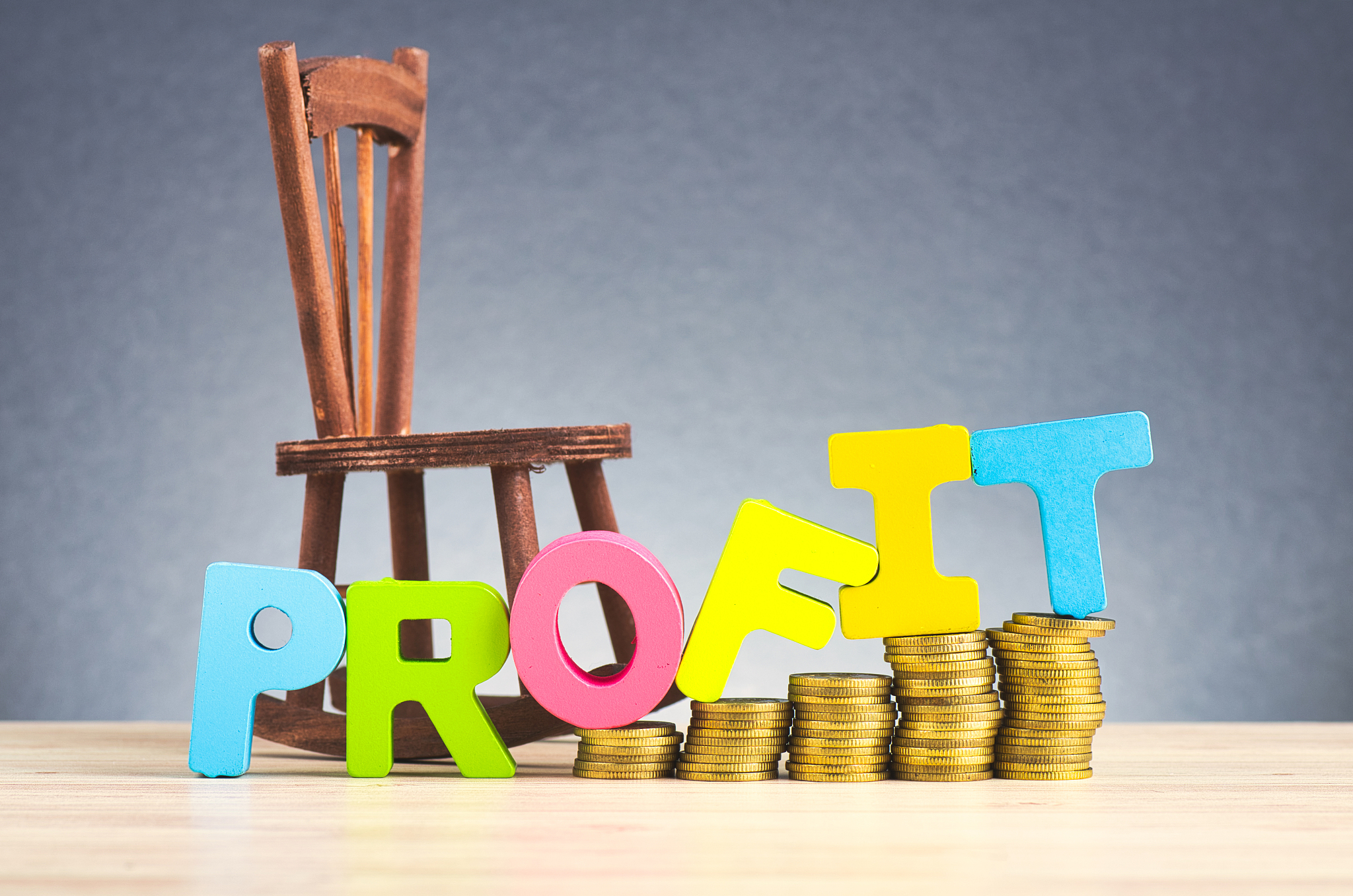 business success concept, stacking coins and word profit on wood