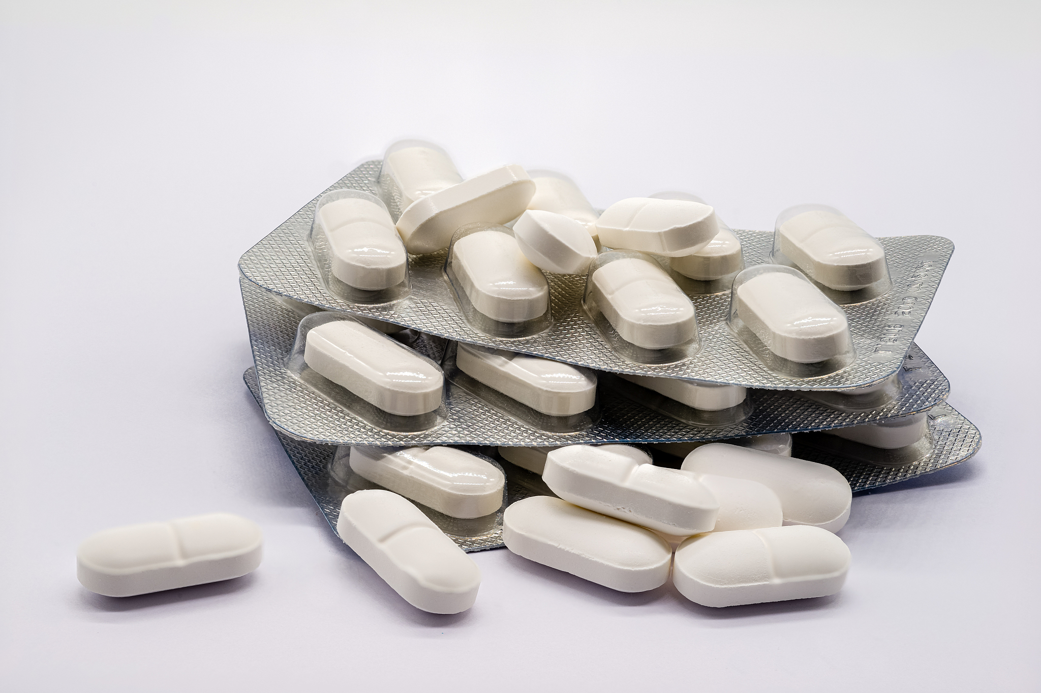 three sleeves of white medical tablets and a number of loose tab