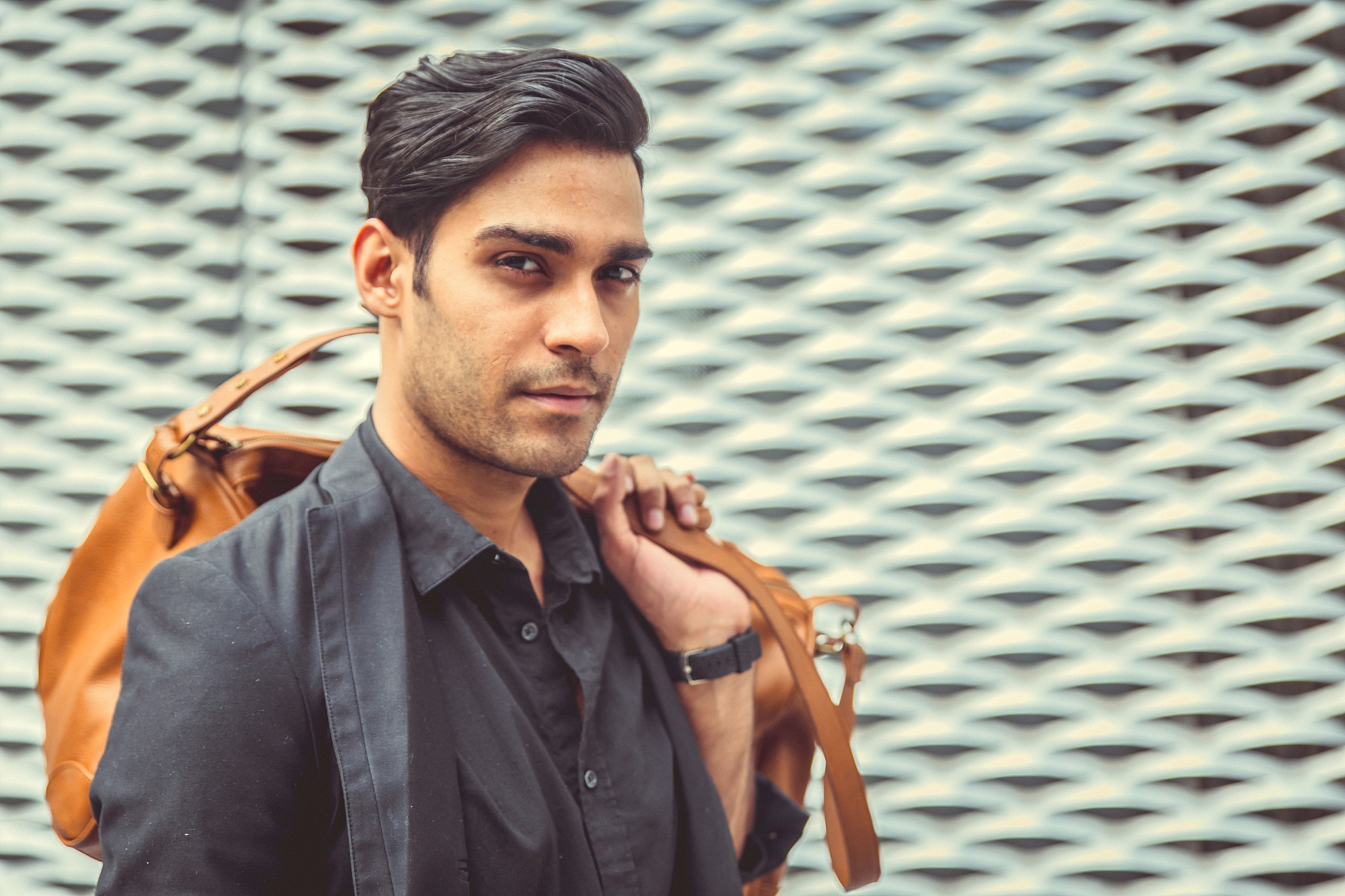 stylish model looking man profile with handbag on his shoulder