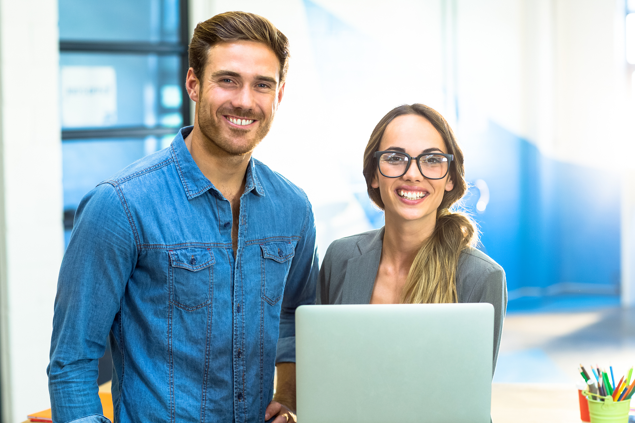 business executives standing with a laptop