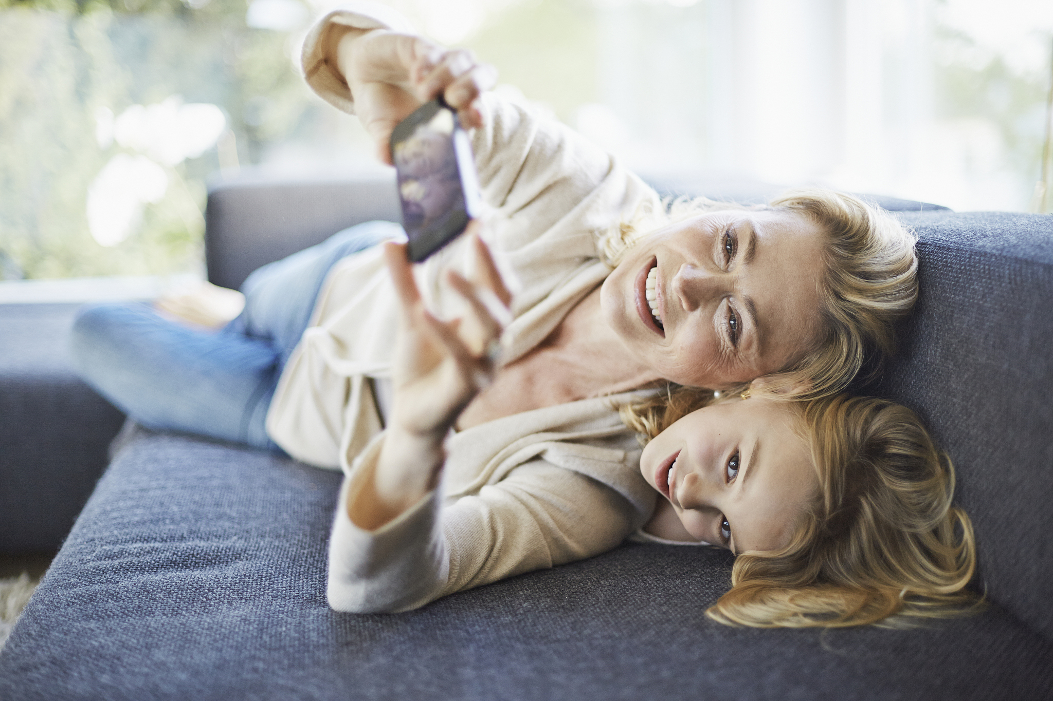 playful grandmother and granddaughter on couch