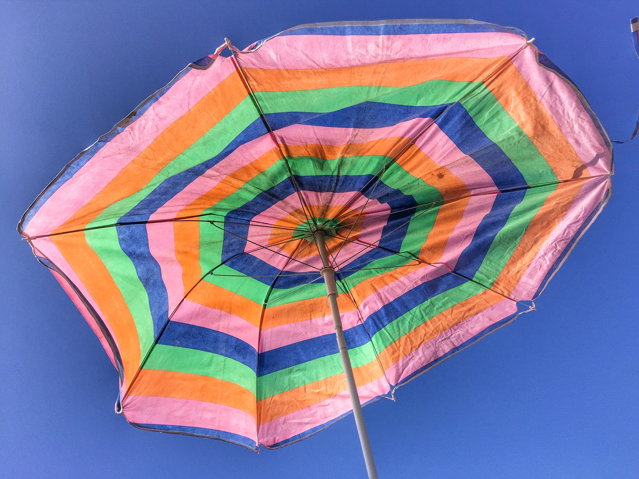 low angle view of multi colored umbrella against blue sky