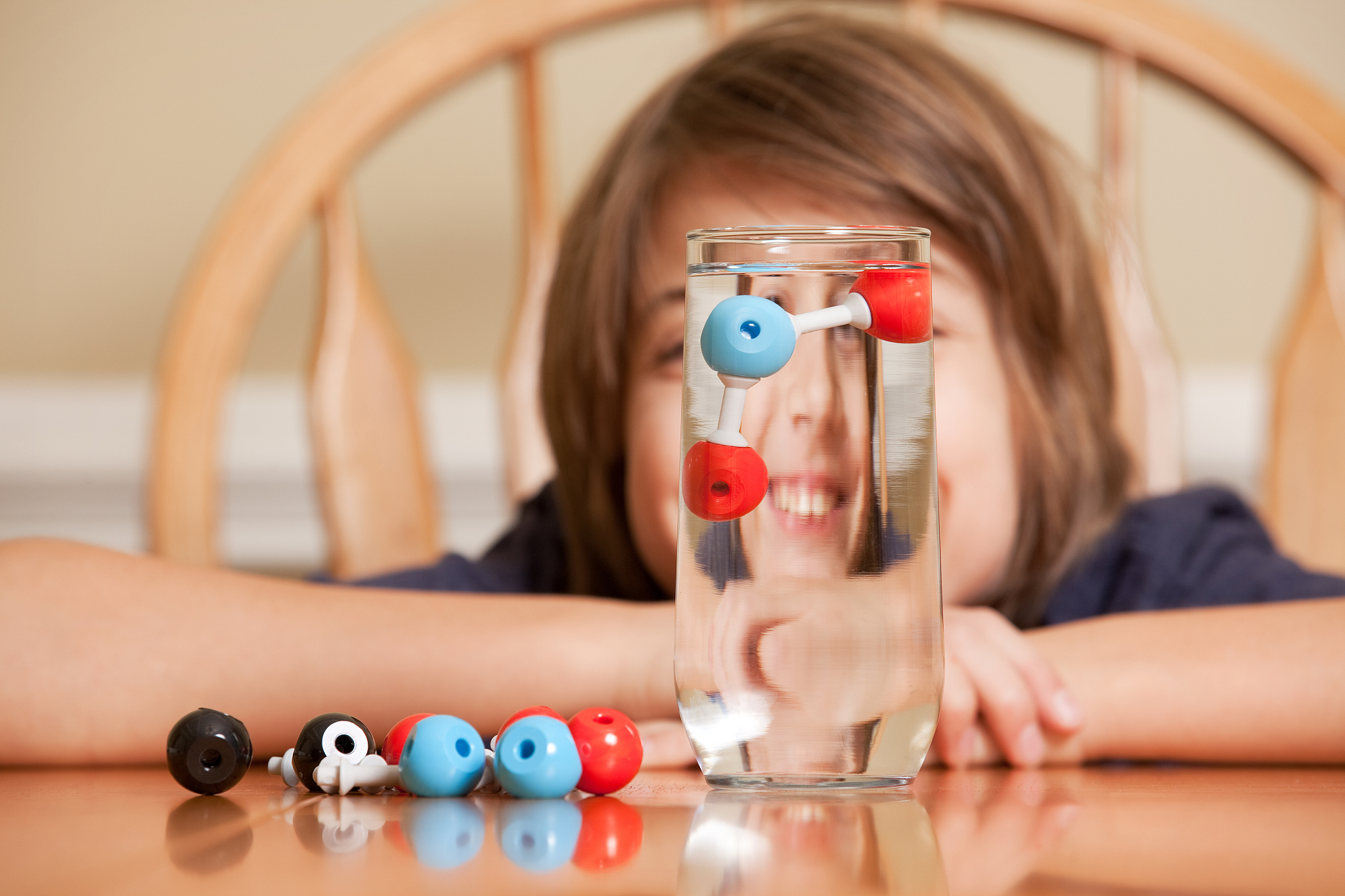 boy with h2o molecule model in water glass
