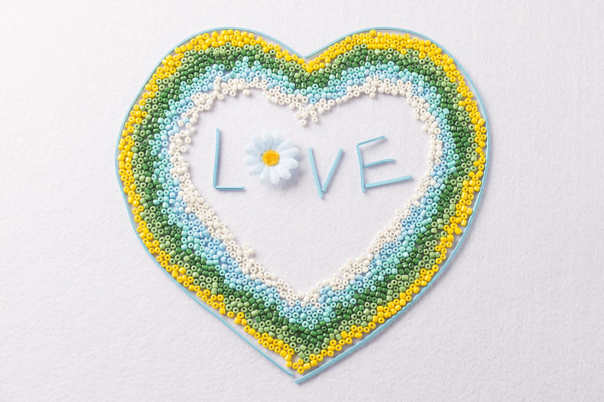 a heart made with colorful tiny beads. love concept.