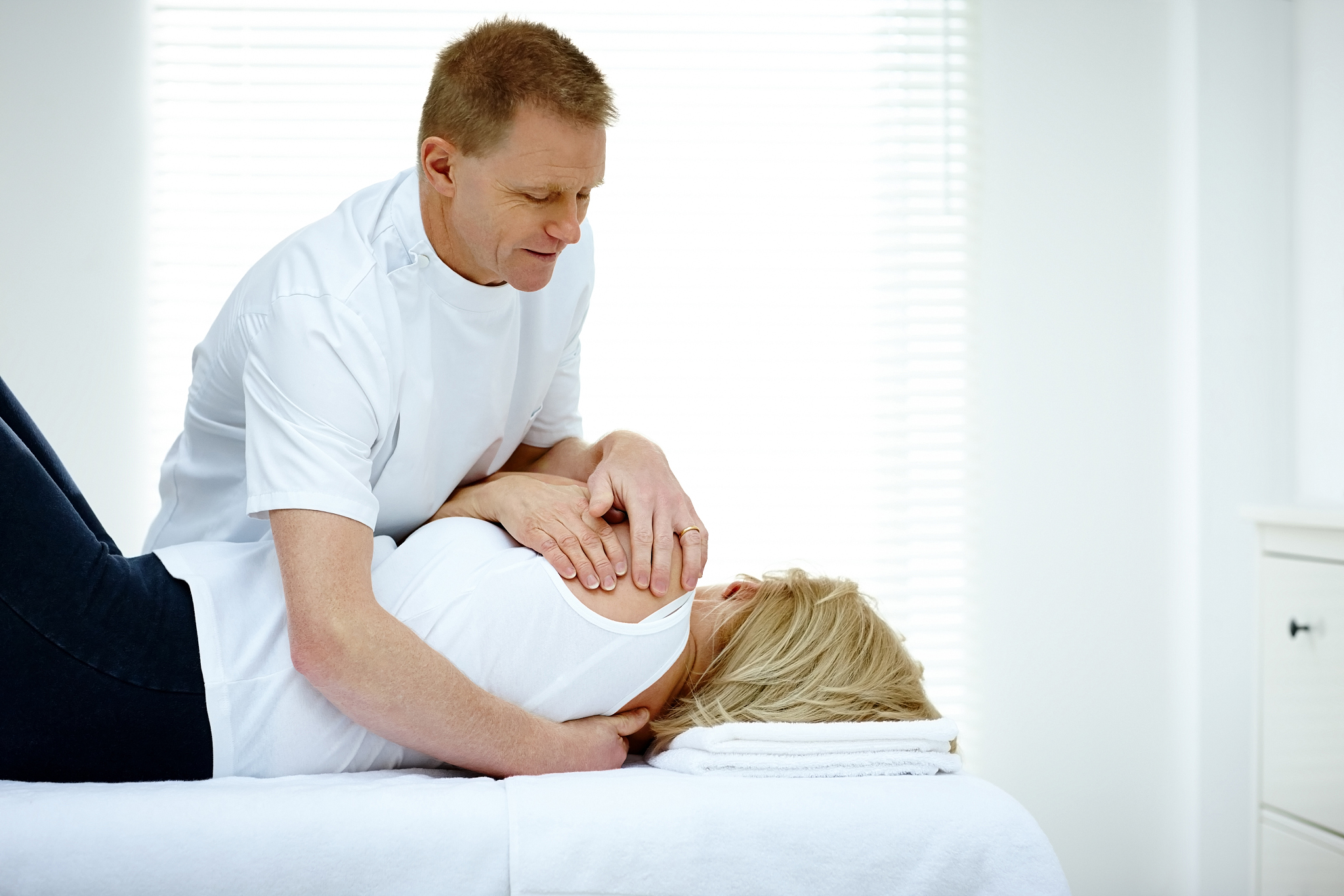 male physiotherapist massaging a senior woman's back