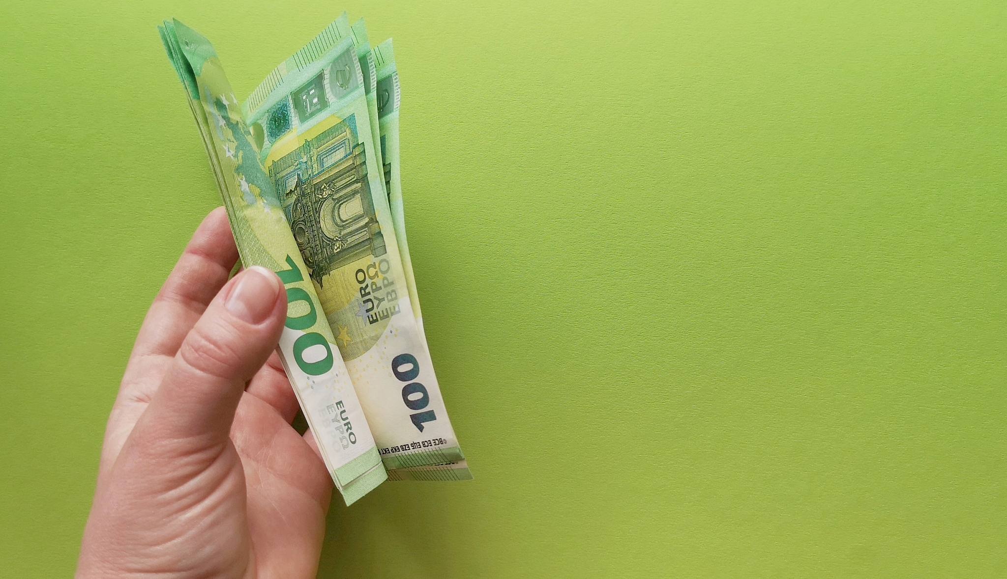 thumb of the left hand flips a stack of euro notes issued in 201