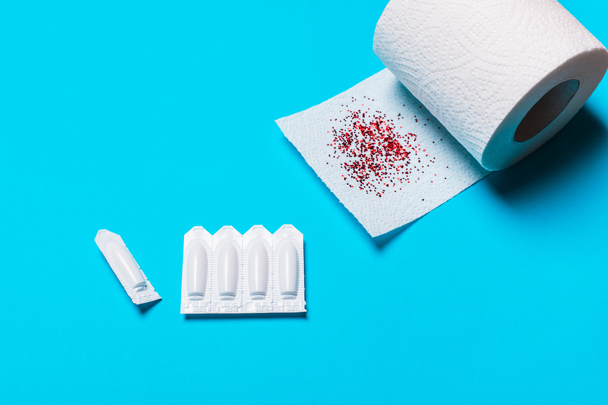suppository and toilet paper on a blue background, f