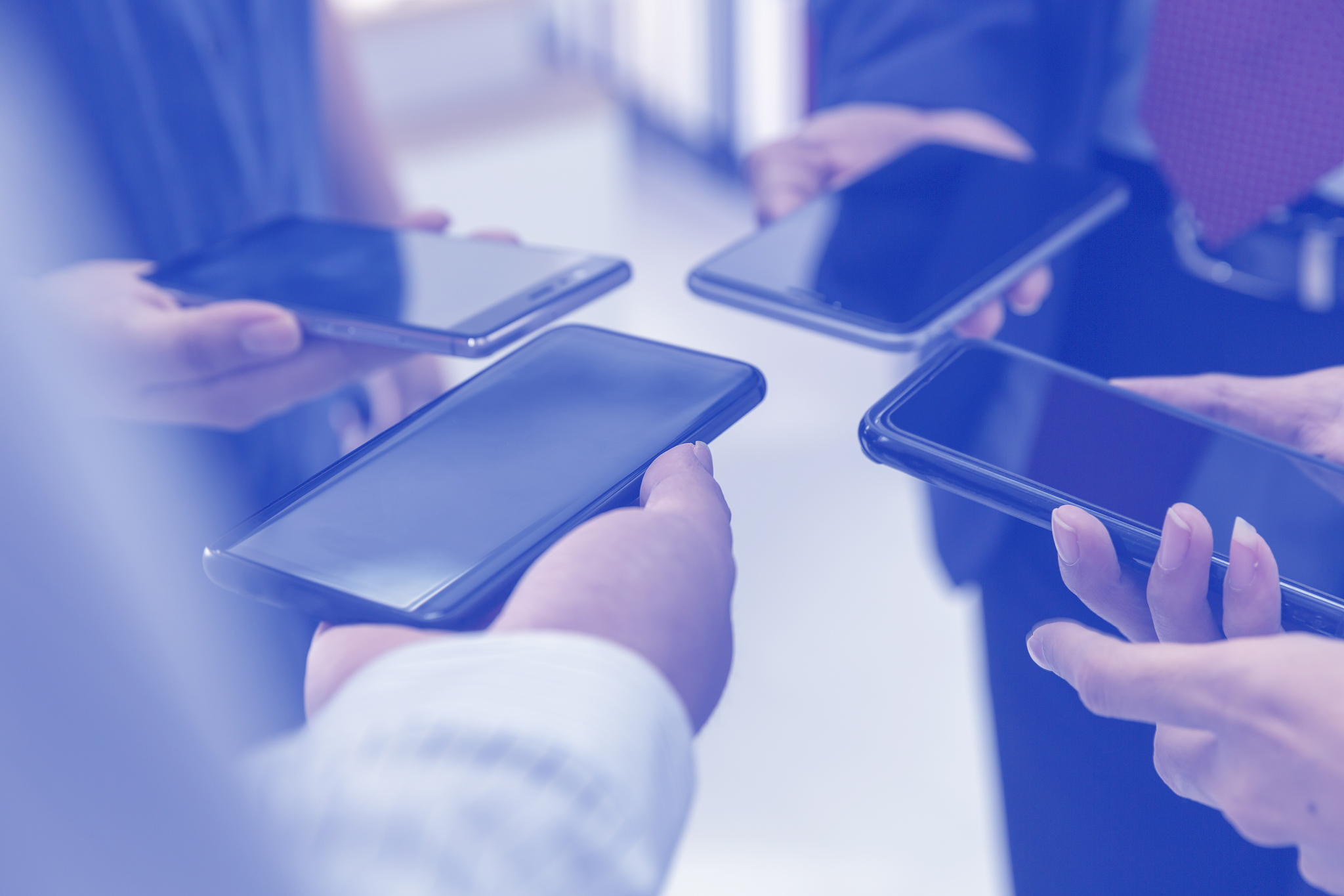 group of people holding the smartphone and standing close to eac