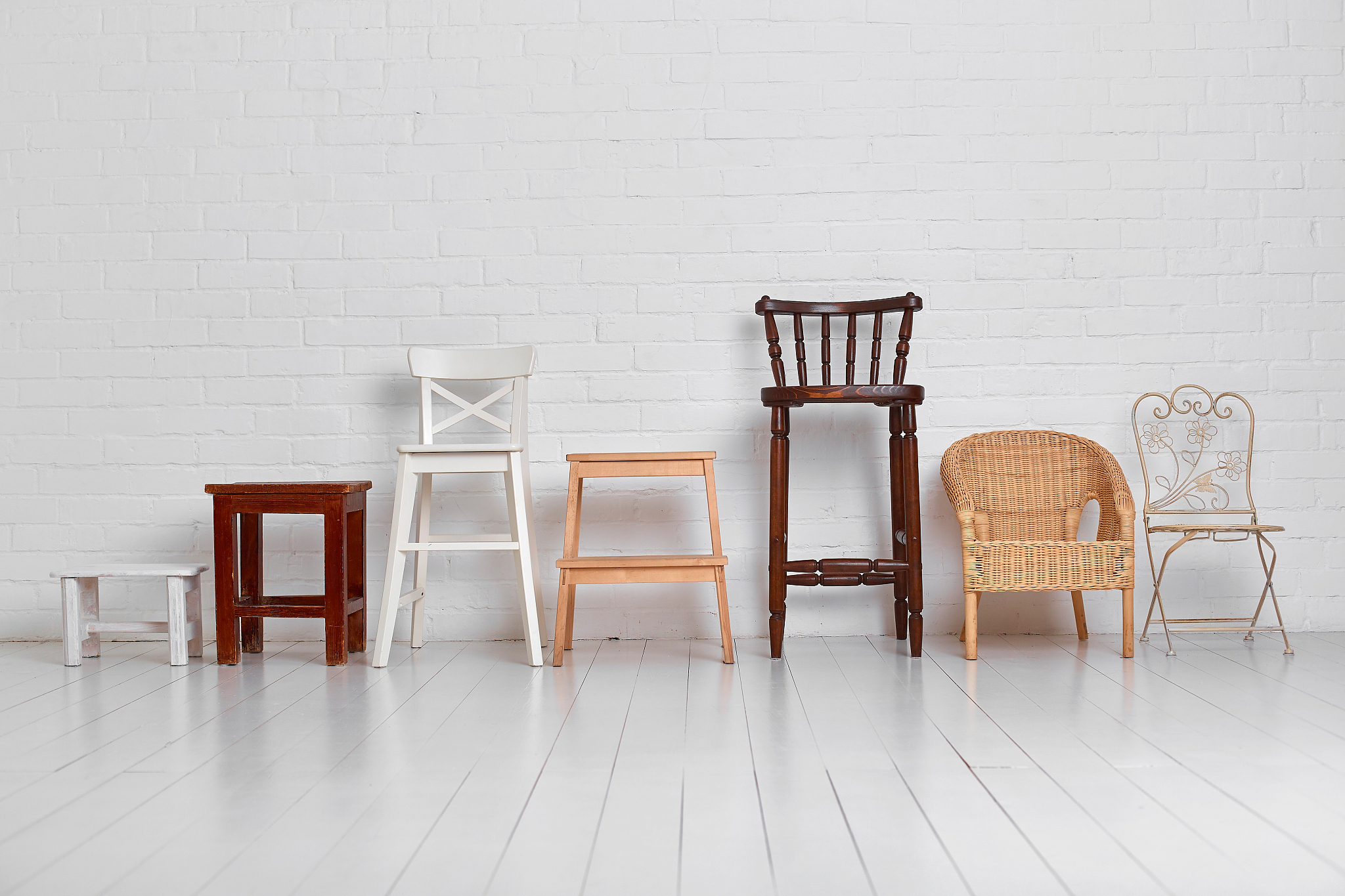 there are many different chairs in the white room. the concept o