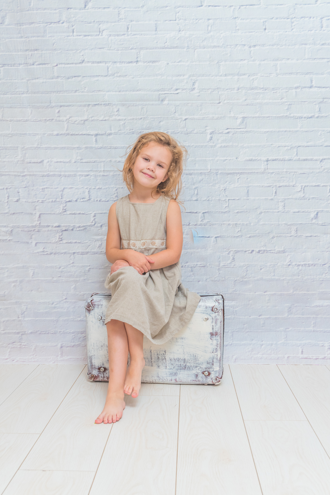 girl, child with suitcase on white brick wall background