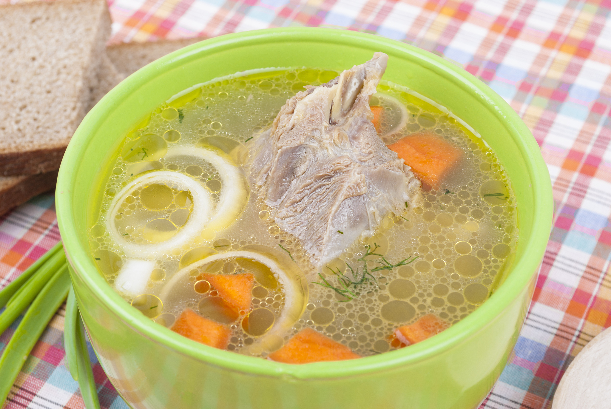 chicken soup with meat and greens on a plate.