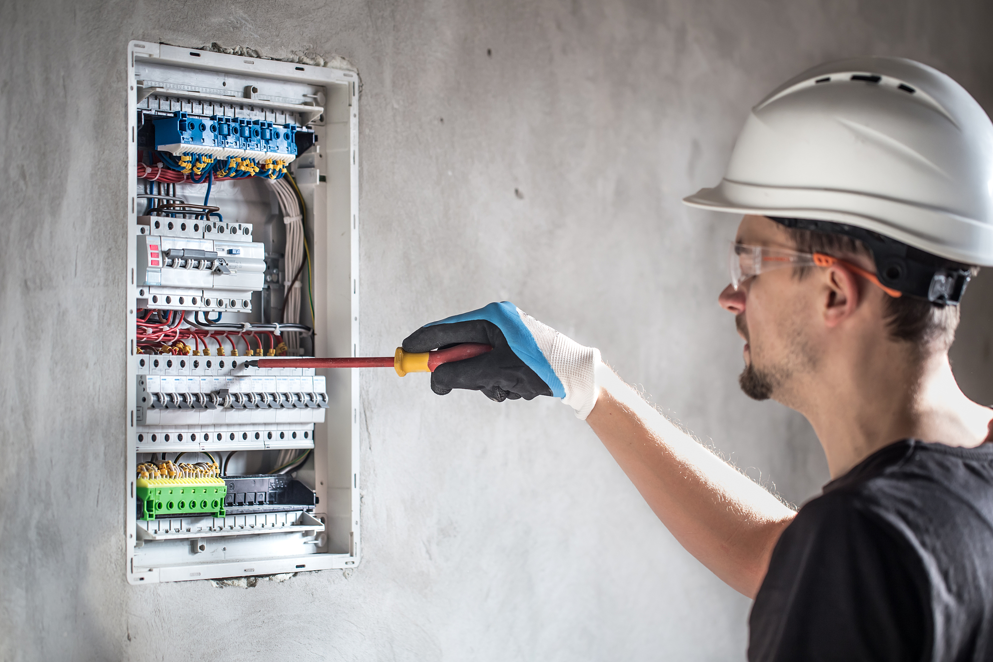 man, an electrical technician working in a switchboard with fuse