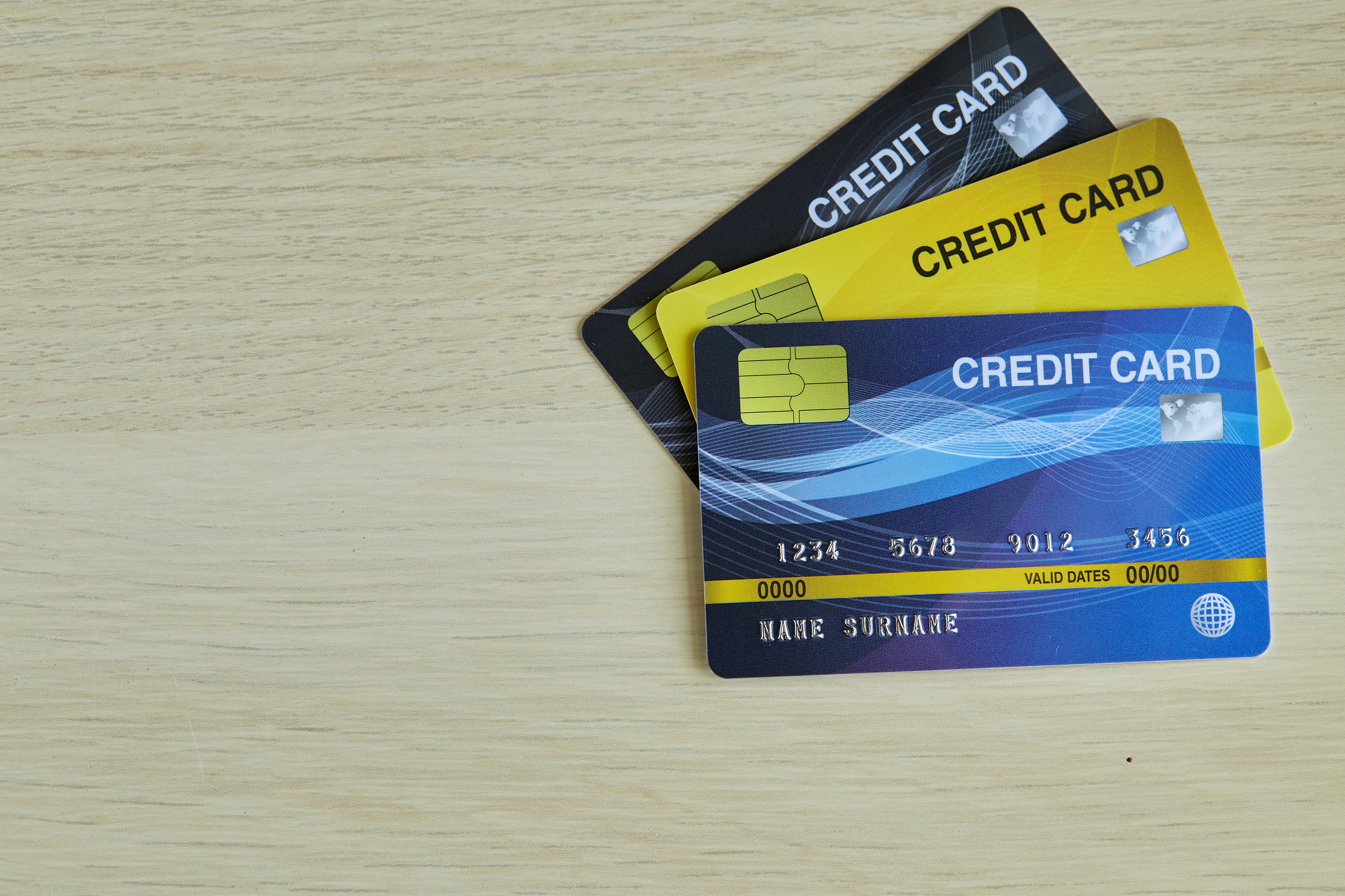 stack of plastic bank credit cards isolated on wooden background