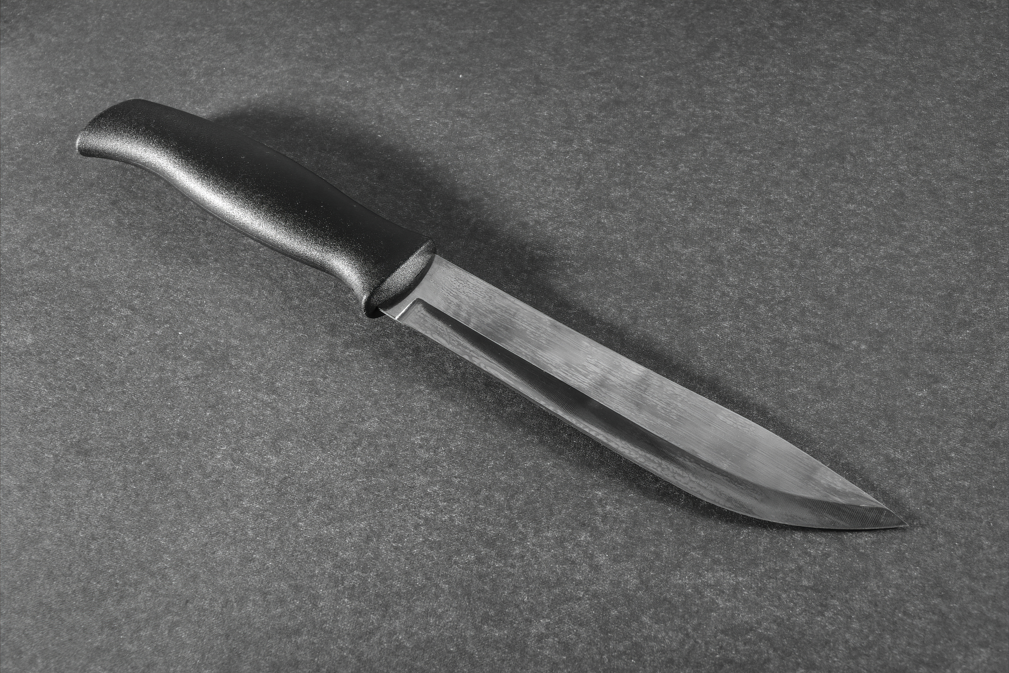 kitchen knive with black handle on a dark grey background.
