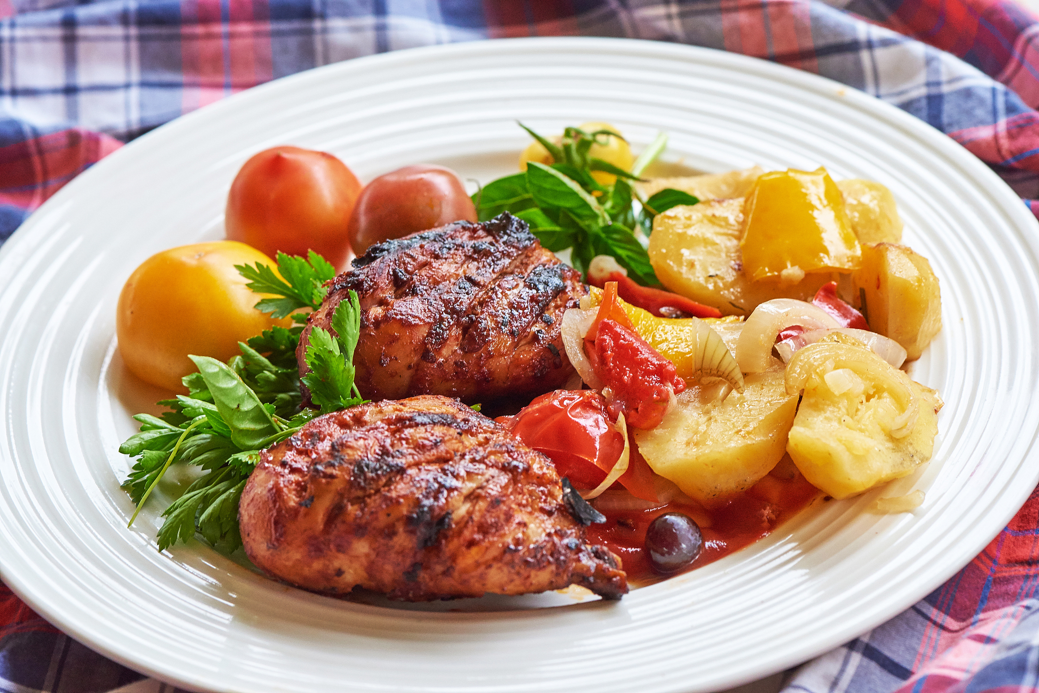 grilled chicken legs with potato and herbs on a plate.