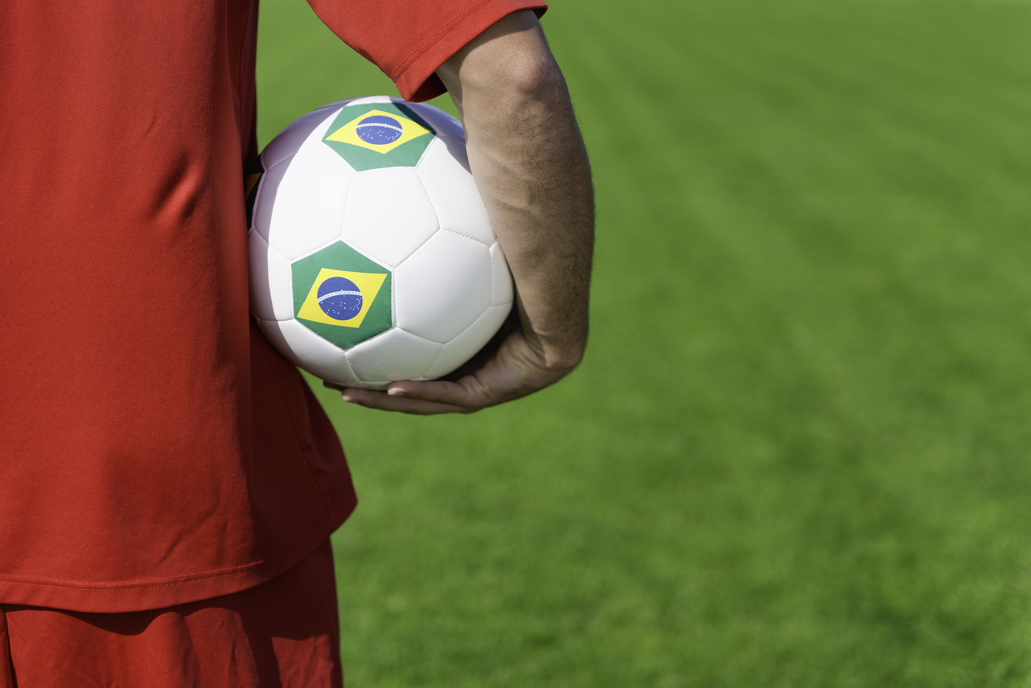 soccer player holding brazil ball