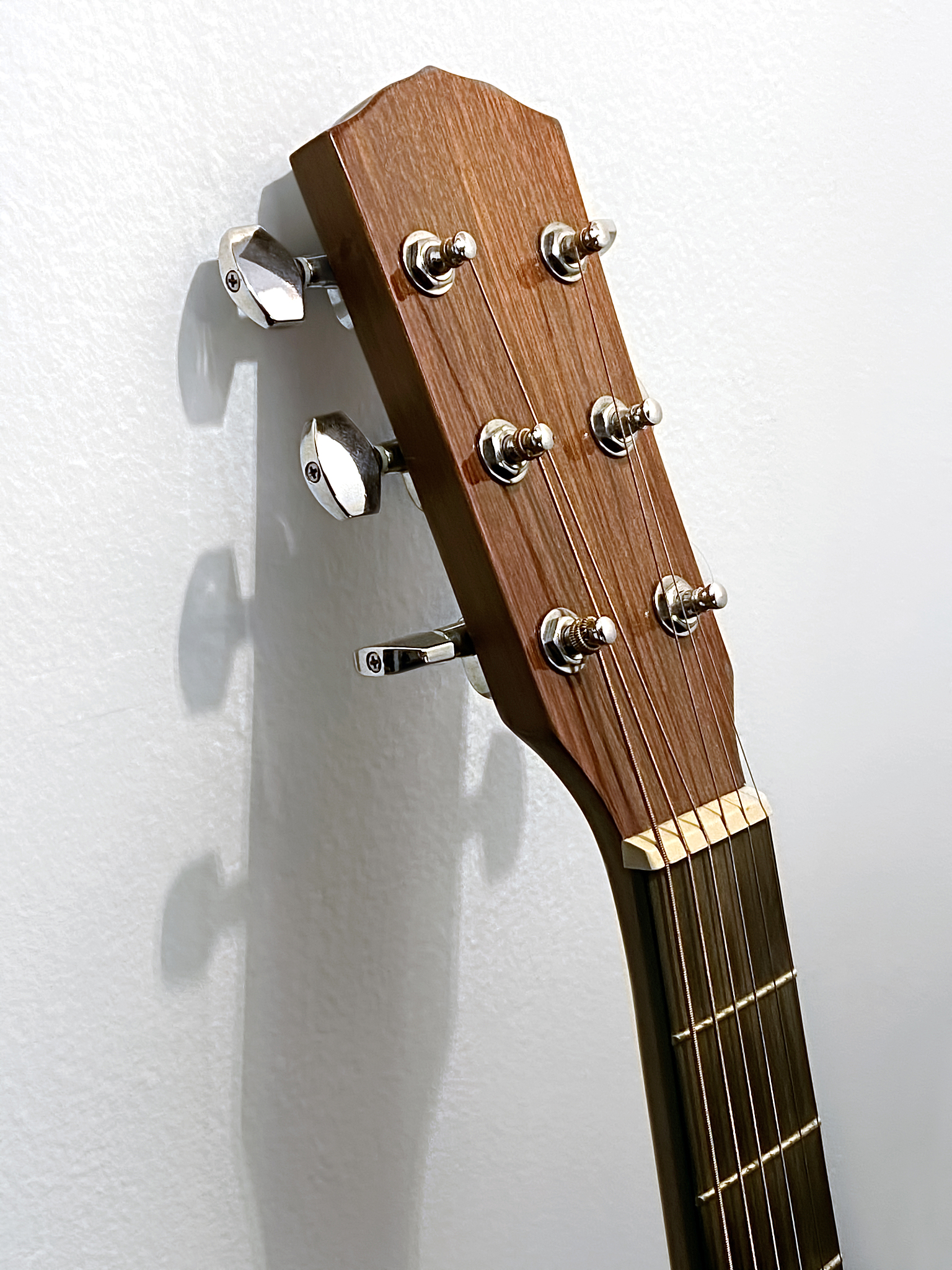 通过设置有限位结构使用第一限位柱与第三限位柱对吉他盖体与吉他座的两端进行限位再配合使用第二限位柱对吉他盖体与吉他座中间位置处的两侧进行限位便完成了对于吉他盖体和吉他座的限位操作同时对吉他盖体与吉他座进行限位能够令吉他盖体更好的盖覆于吉他座的顶部一定程度的降低了因吉他盖体的盖覆位置出现偏移导致拼板错位的问题出现并且此种限位的结构简单如果此类结构损坏不会造成较大的经济损失实用性更好。前面内容简写