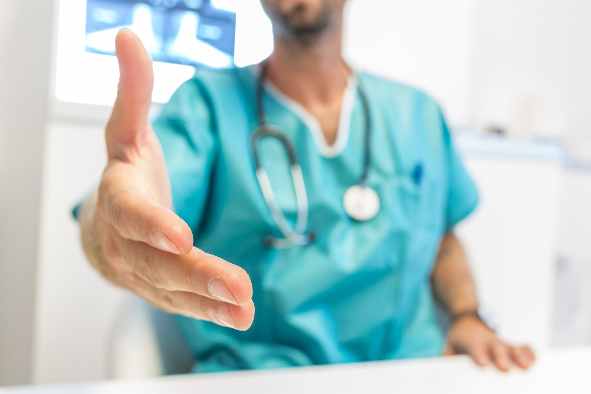young surgeon doctor reaches out to us, close up hand