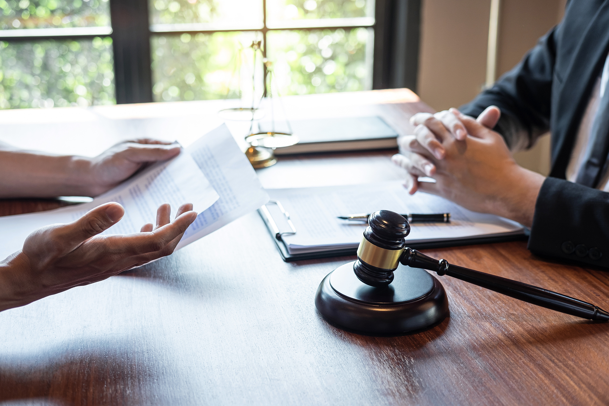 midsection of lawyer discussing document with client in courtroo