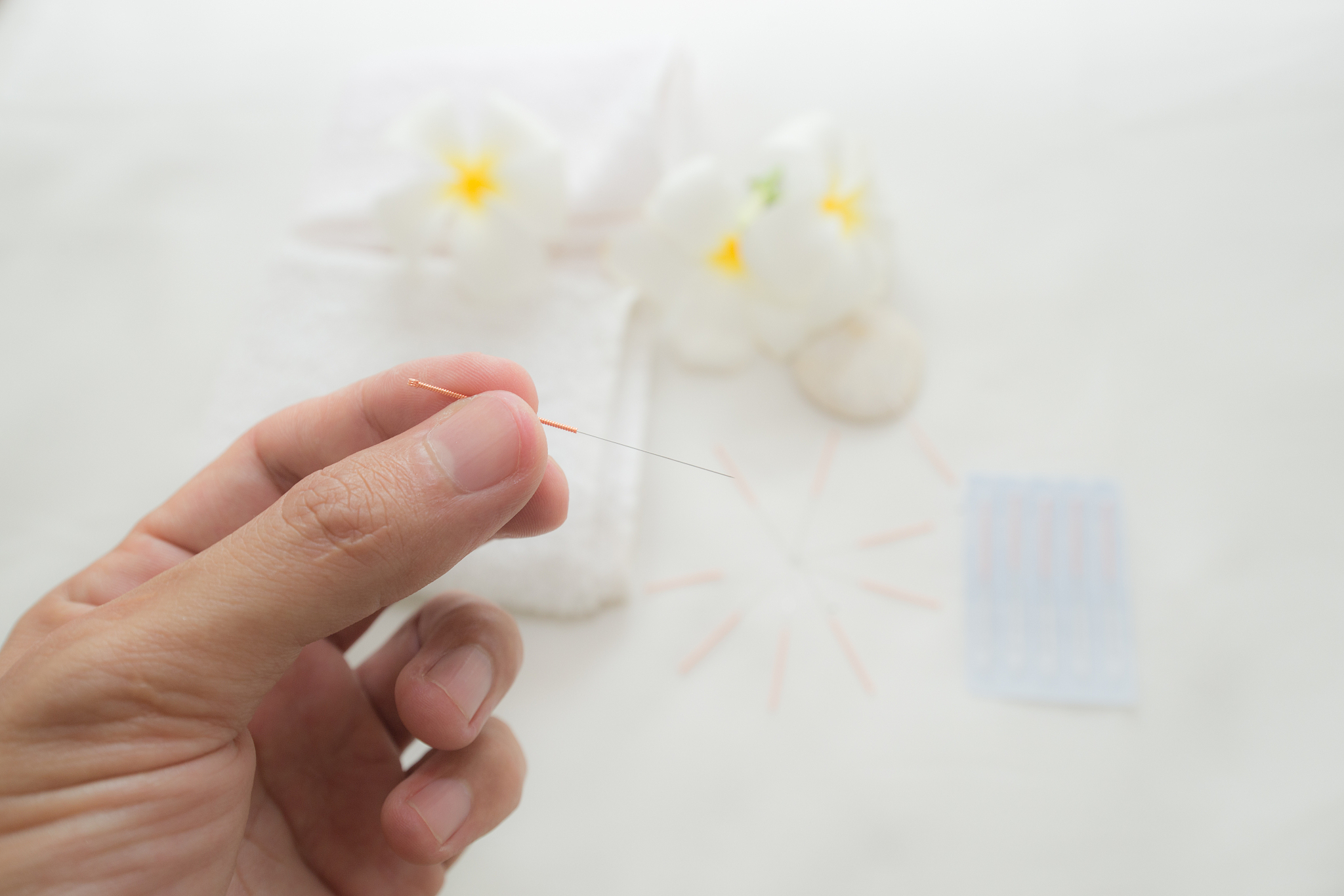 close-up of cropped hand holding acupuncture needle