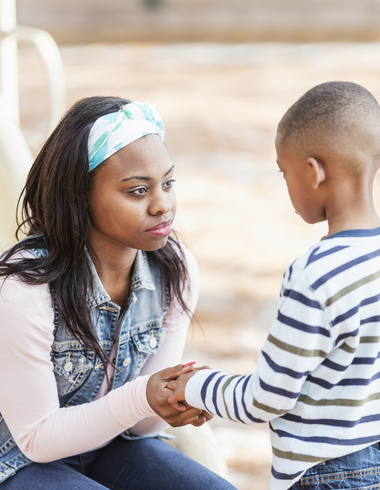 mother talking to little boy on playground