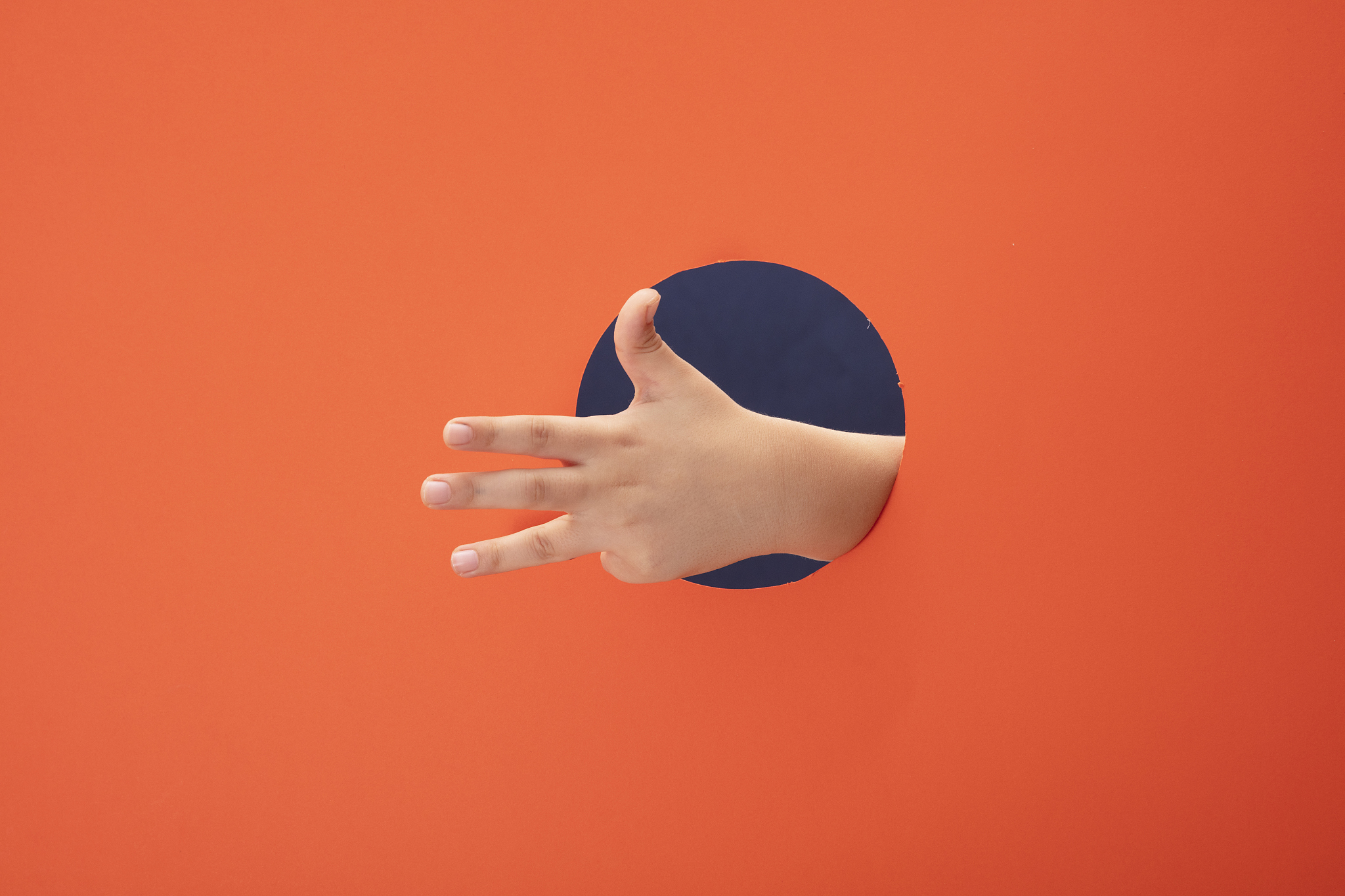 little boy hand with showing number four on orange paper backgro