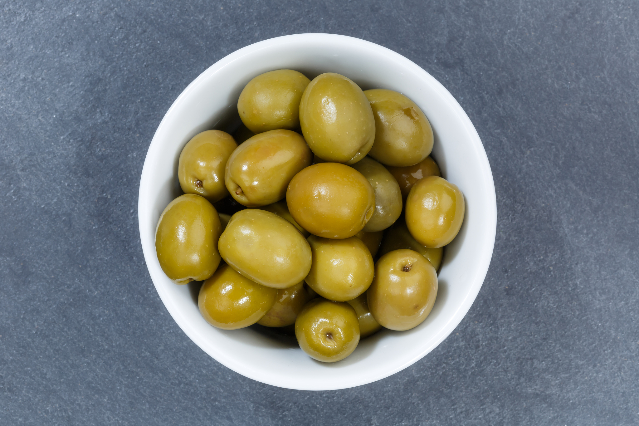 olives green olive from above bowl on a slate