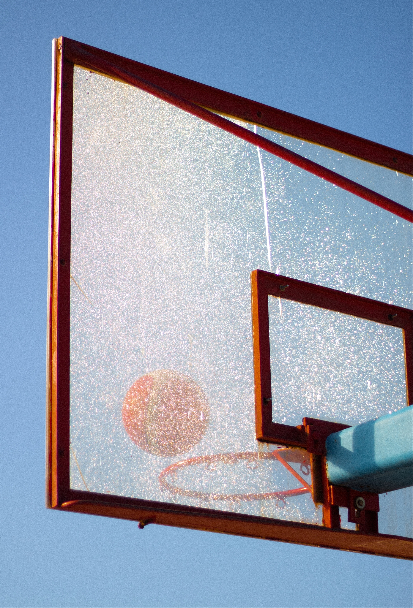 a ball going into a basket and all that against a blue sky, this