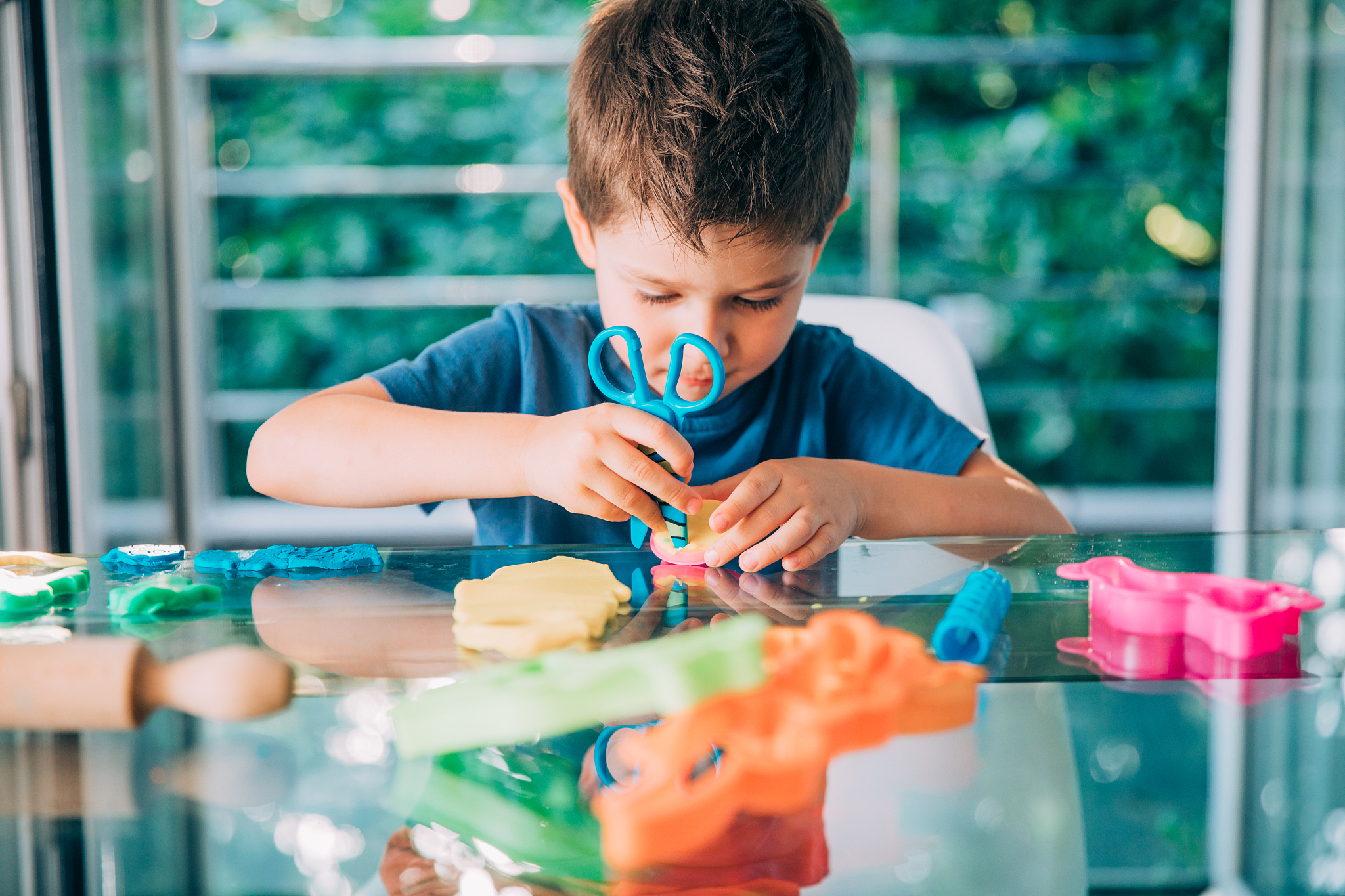 preschool boy playing with child's play clay