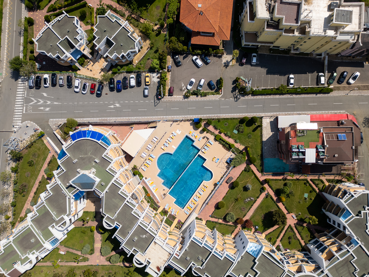 在南方某城市滨水区拟建一个居住小区要求体现滨水区空间和景观环境特 色。规划用地范围内地形平坦 沿江大道为城市主干道其余为次干道和支路。规划设计技术规定如下： 日照间距系数11容积率10占地140700平方米不允许建高层绿地率30按居住小区要求配建公共服务设施。要求从以下方面写出规划方案构思过程和计算结果 1车行出入口位置和数量的确定 2小区级道路和景观轴线方向设计构思 3小区中心绿地和组团绿地设计