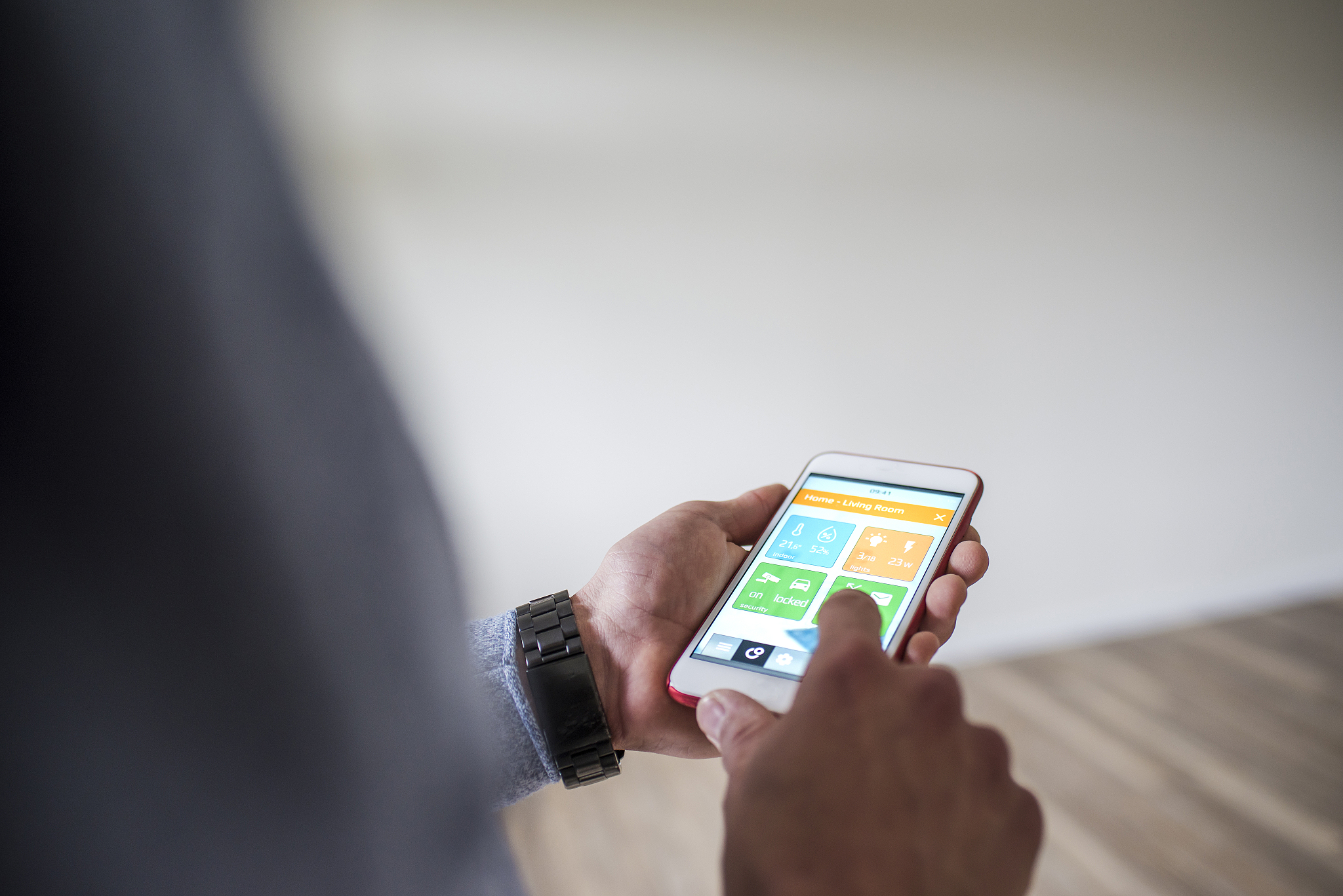 man at home using smartphone with smart home apps