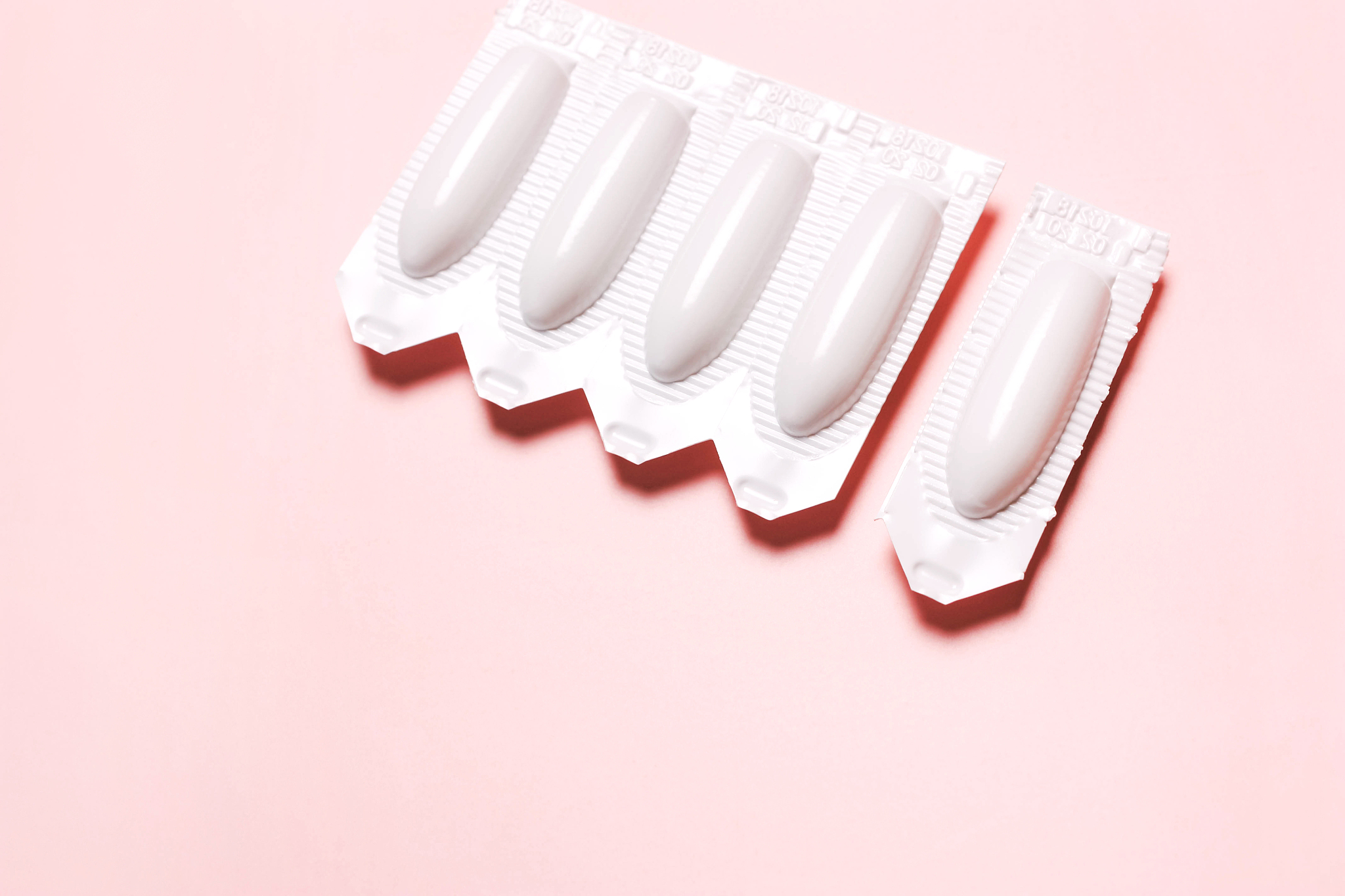 vaginal suppository on a pink background, for the treatment of h