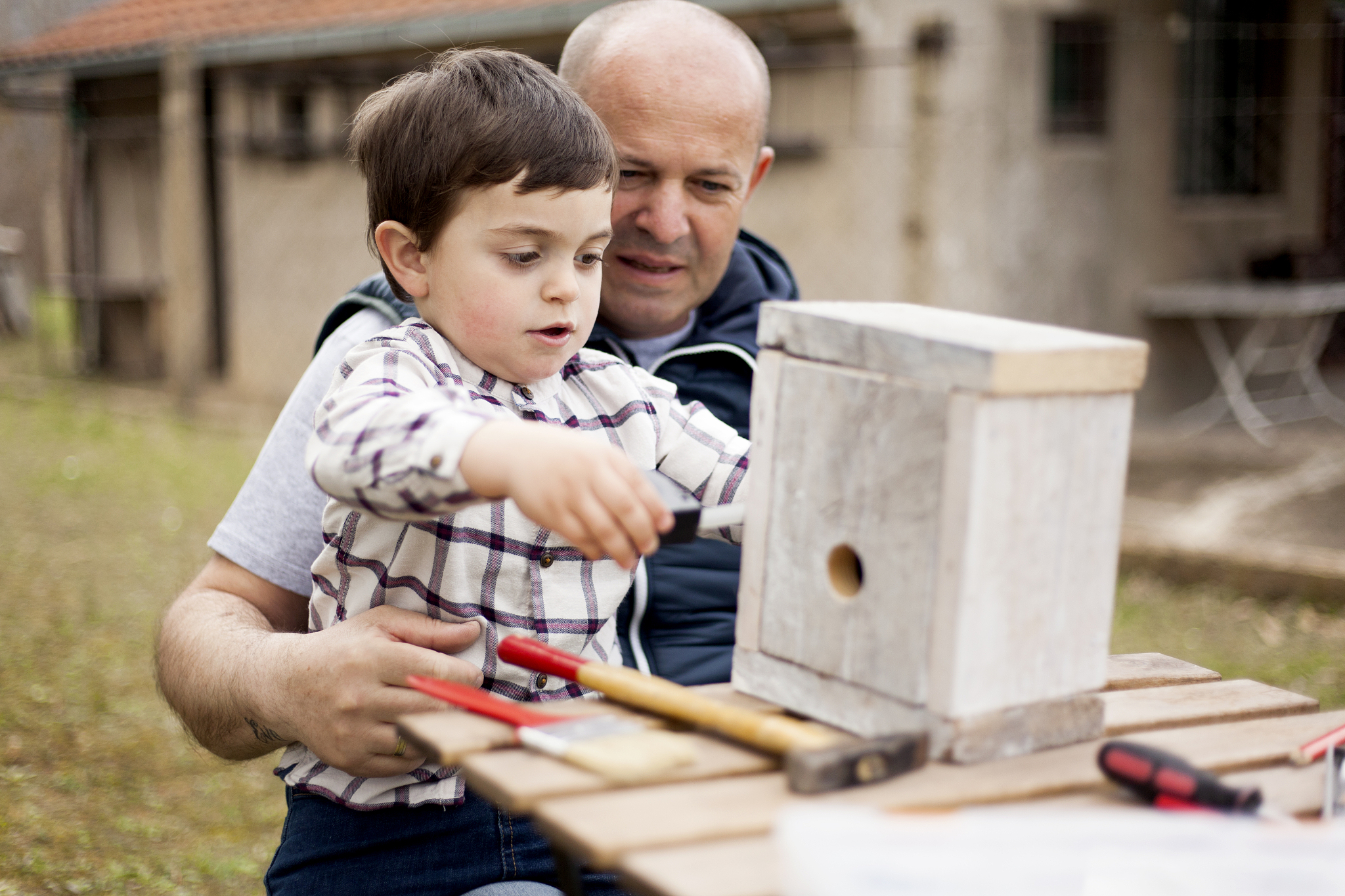 father and son building birdhouse outdoor