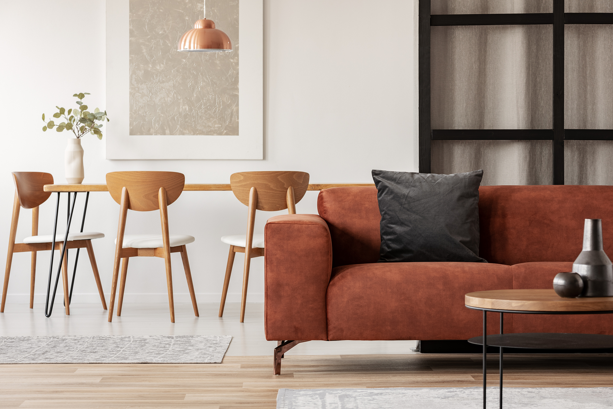 stylish corner sofa with black pillow in open space studio apart