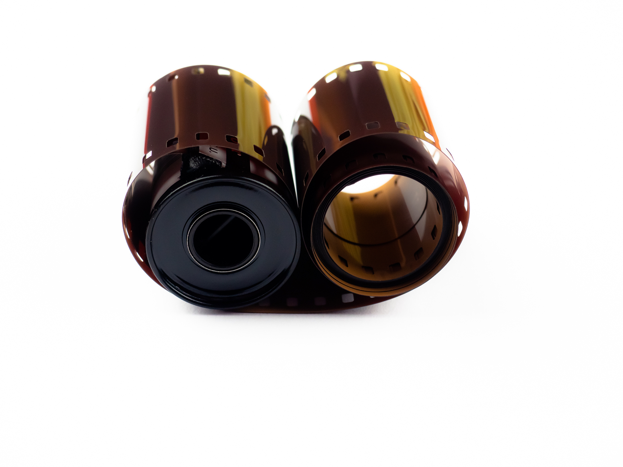 close-up of spiral roll of 35mm photographic film on white backg