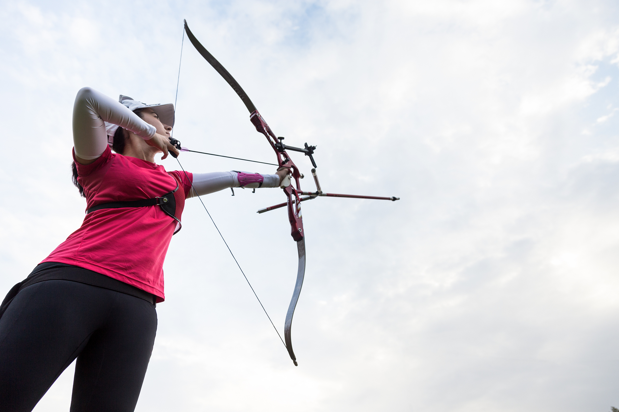 female athlete practicing archery in stadium