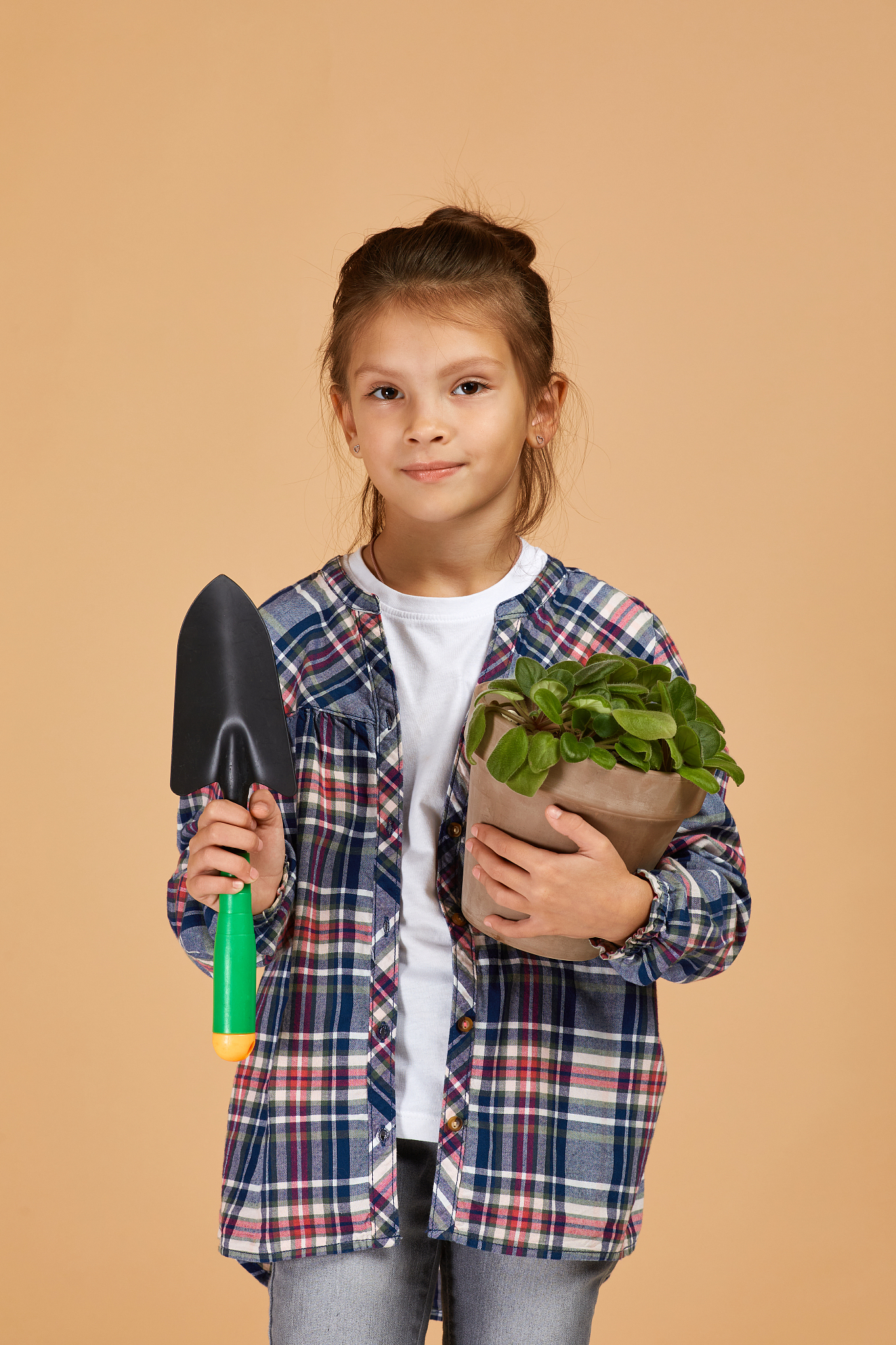 little girl watering plants in a flower pot