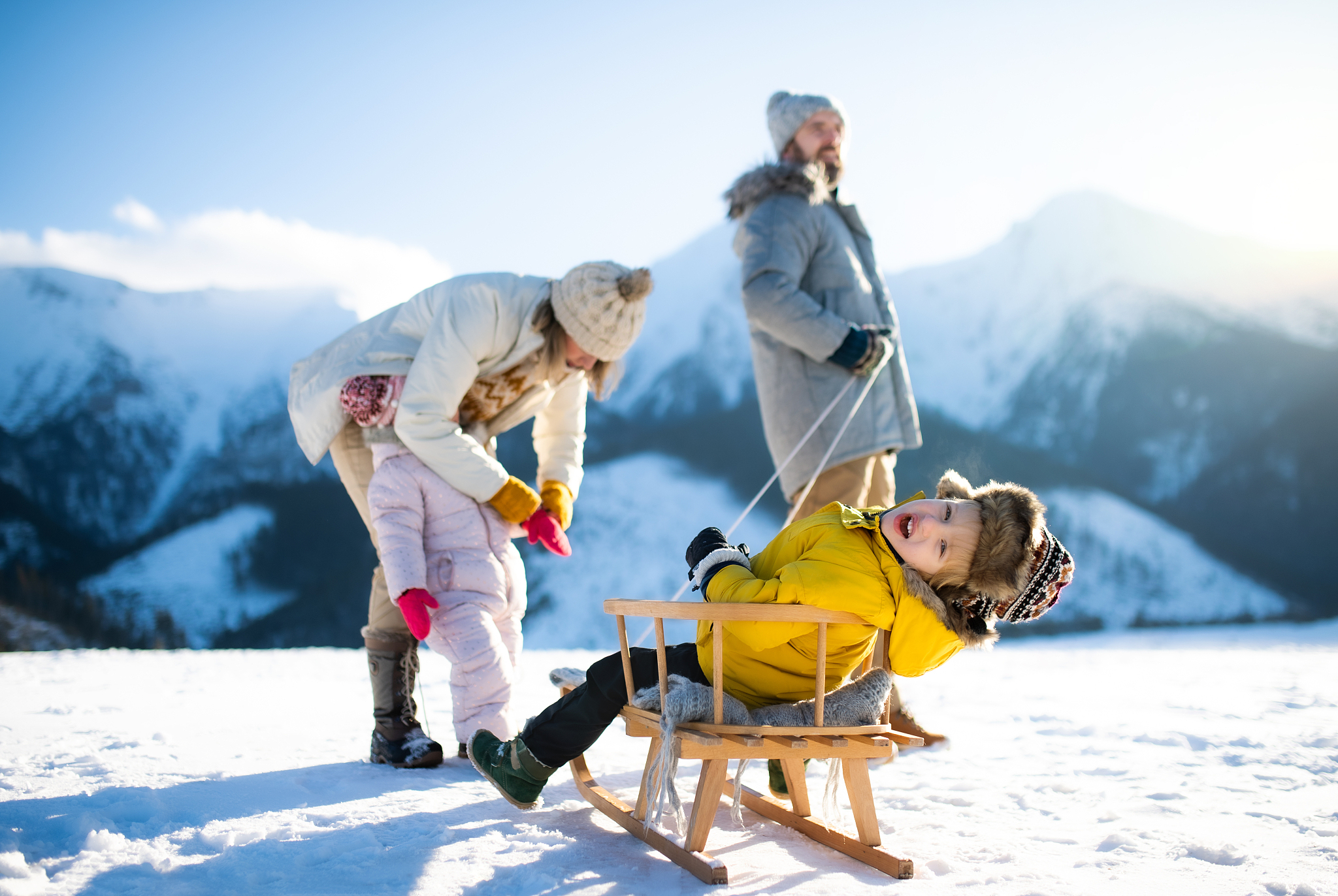 portrait of family with two small children enjoying snow in wint