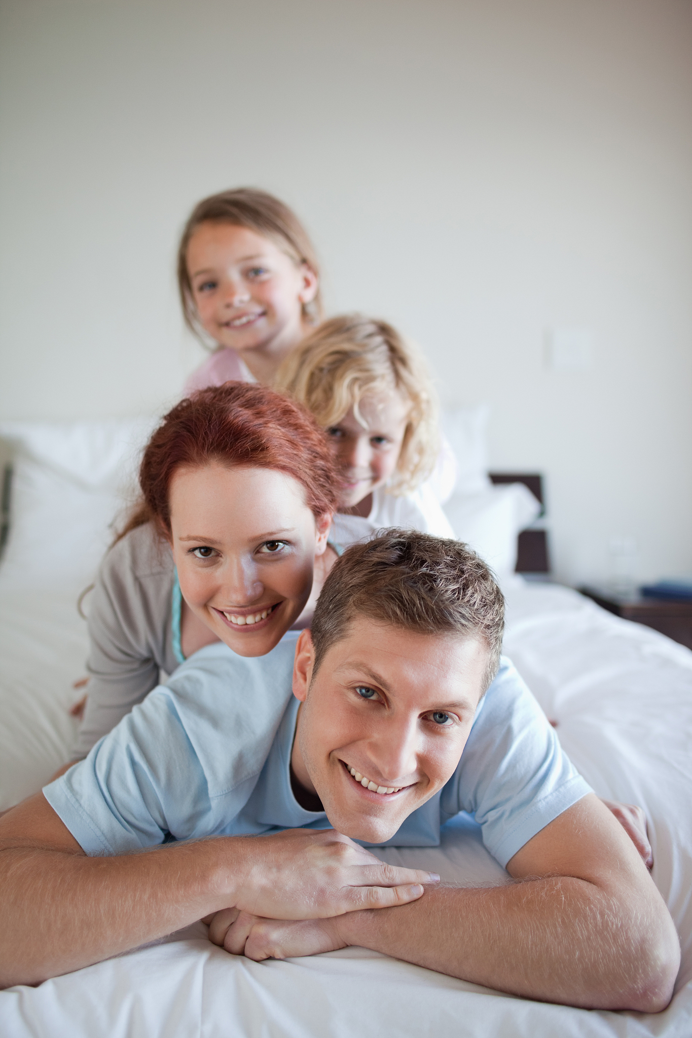playful family together on the bed