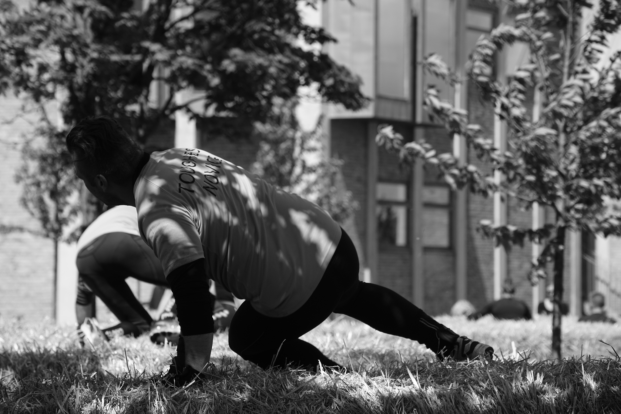 men exercising on grassy field at park